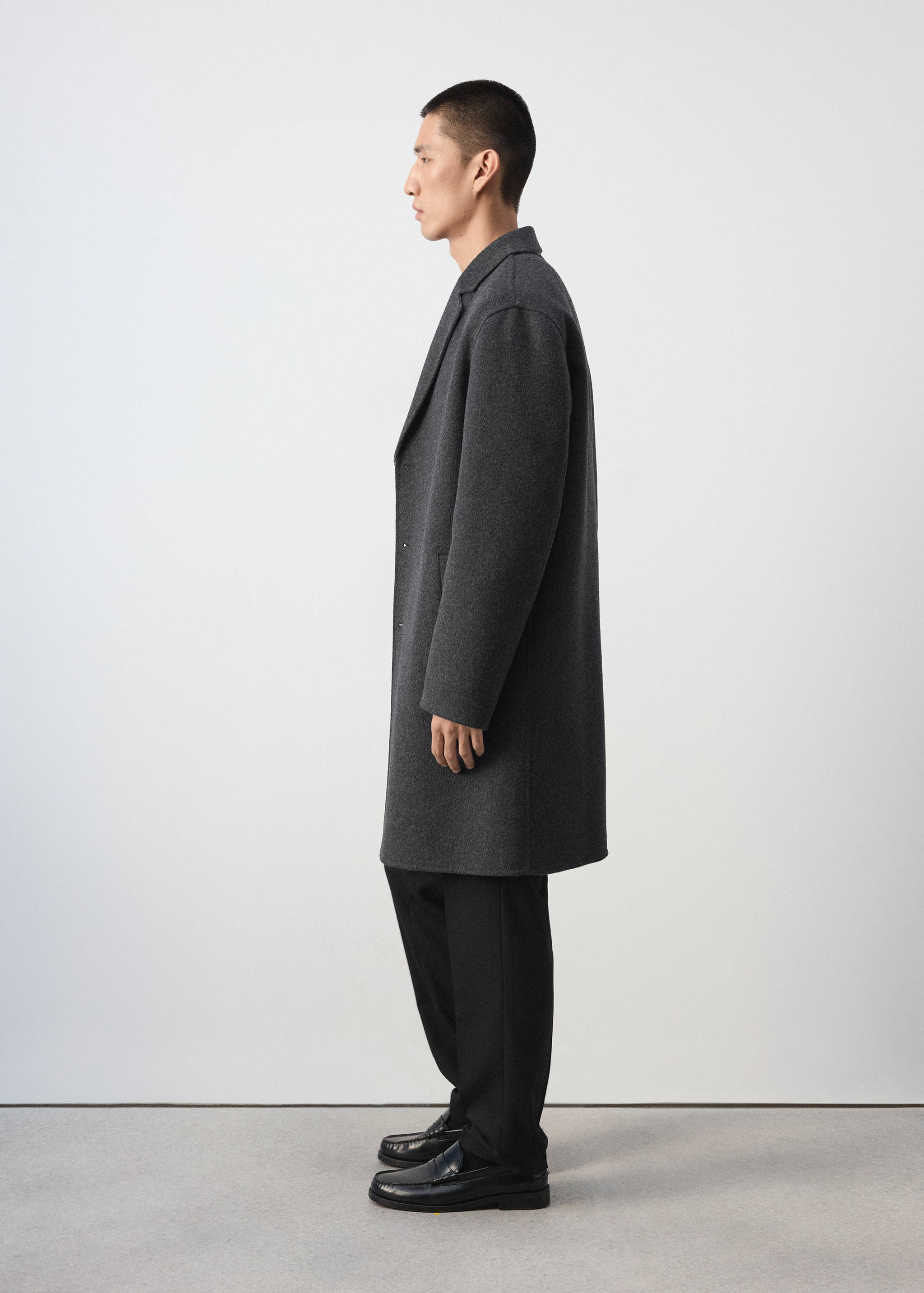Dark grey coat with a lapel collar in a side-profile view.