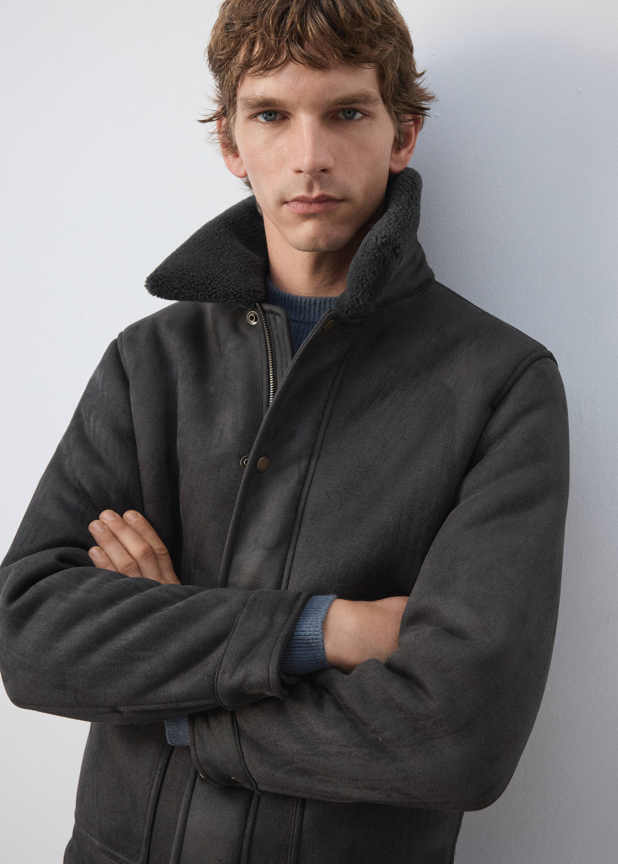 Dark grey jacket with high shearling-lined collar and front snaps, worn by a model.