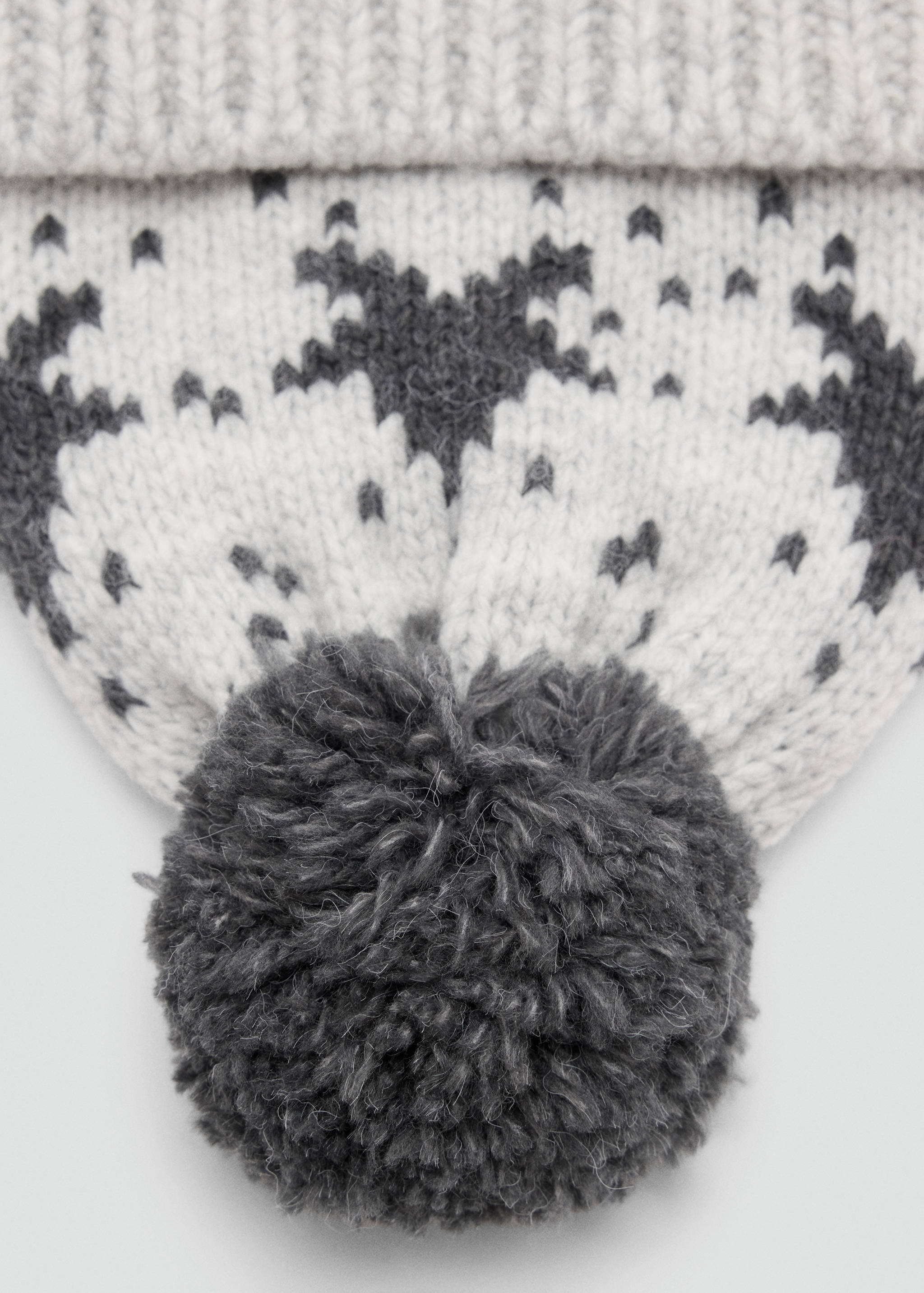 Grey knit beanie with Nordic pattern and pom-pom, accessory detail.