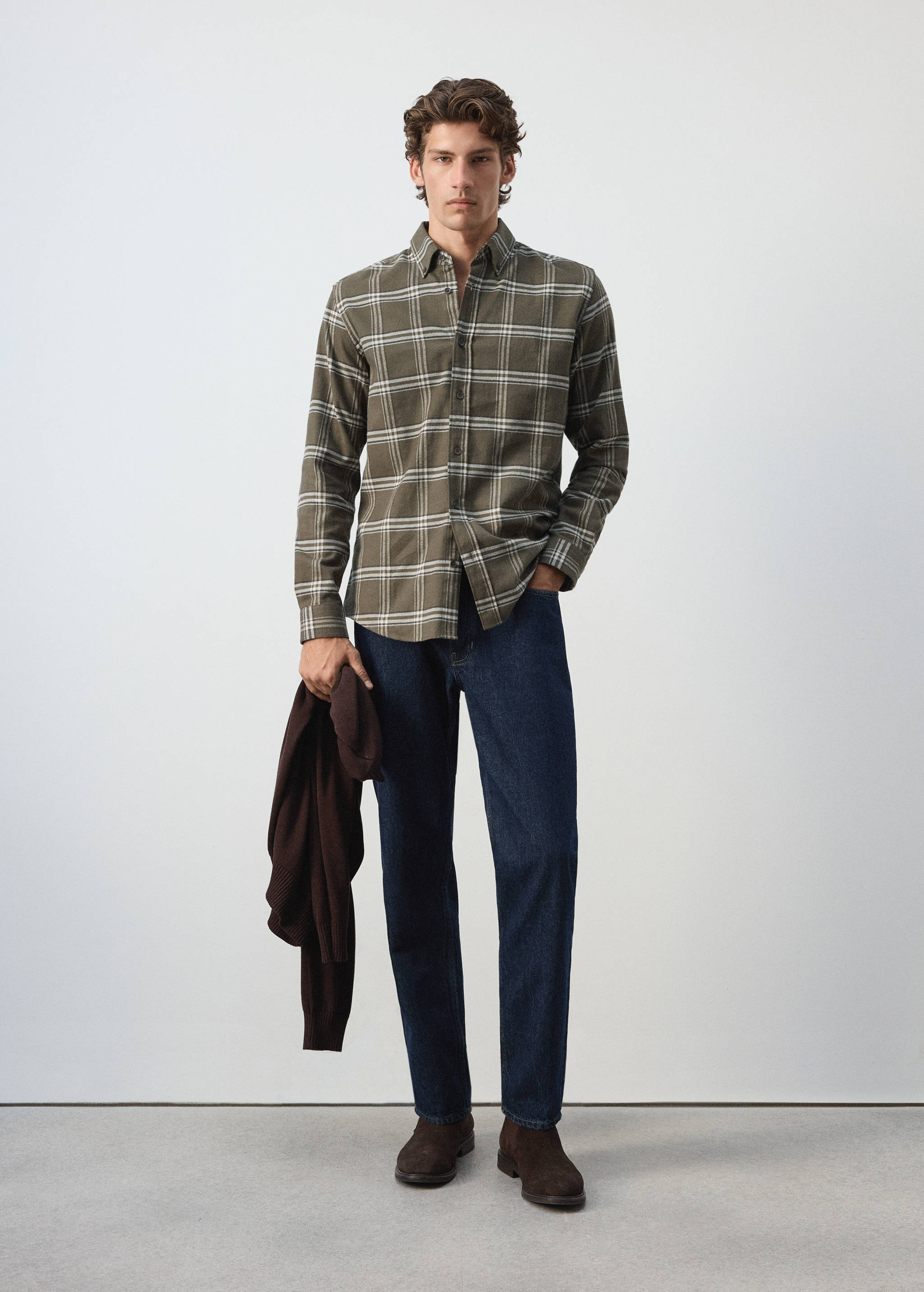 Olive green plaid overshirt worn with dark blue jeans.