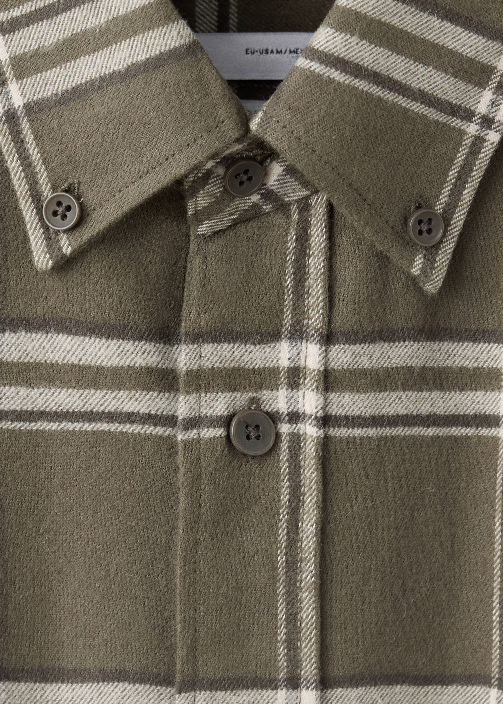 Close-up of an olive green plaid overshirt with a button-down collar.