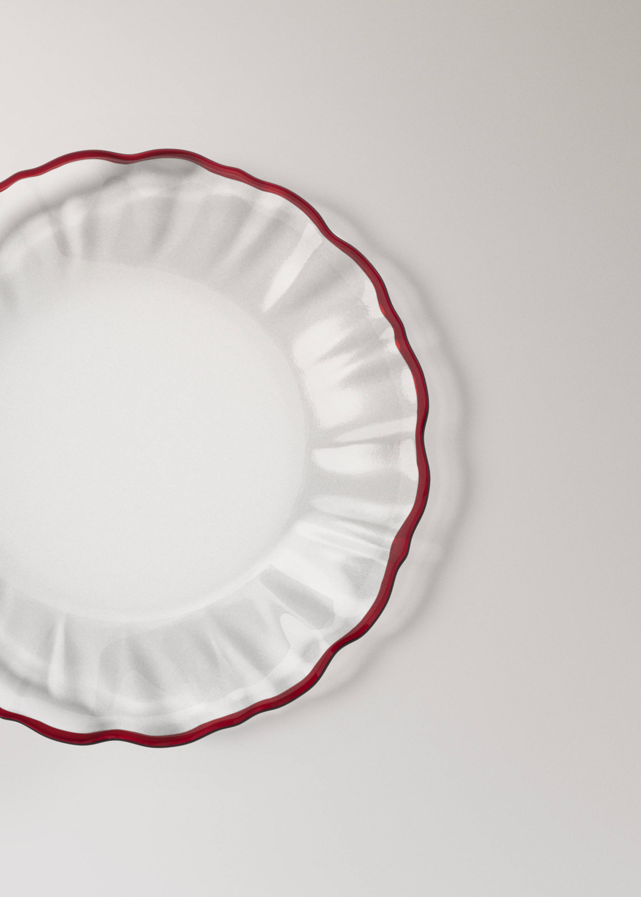 Clear glass plate with a wavy rim and red border detail.