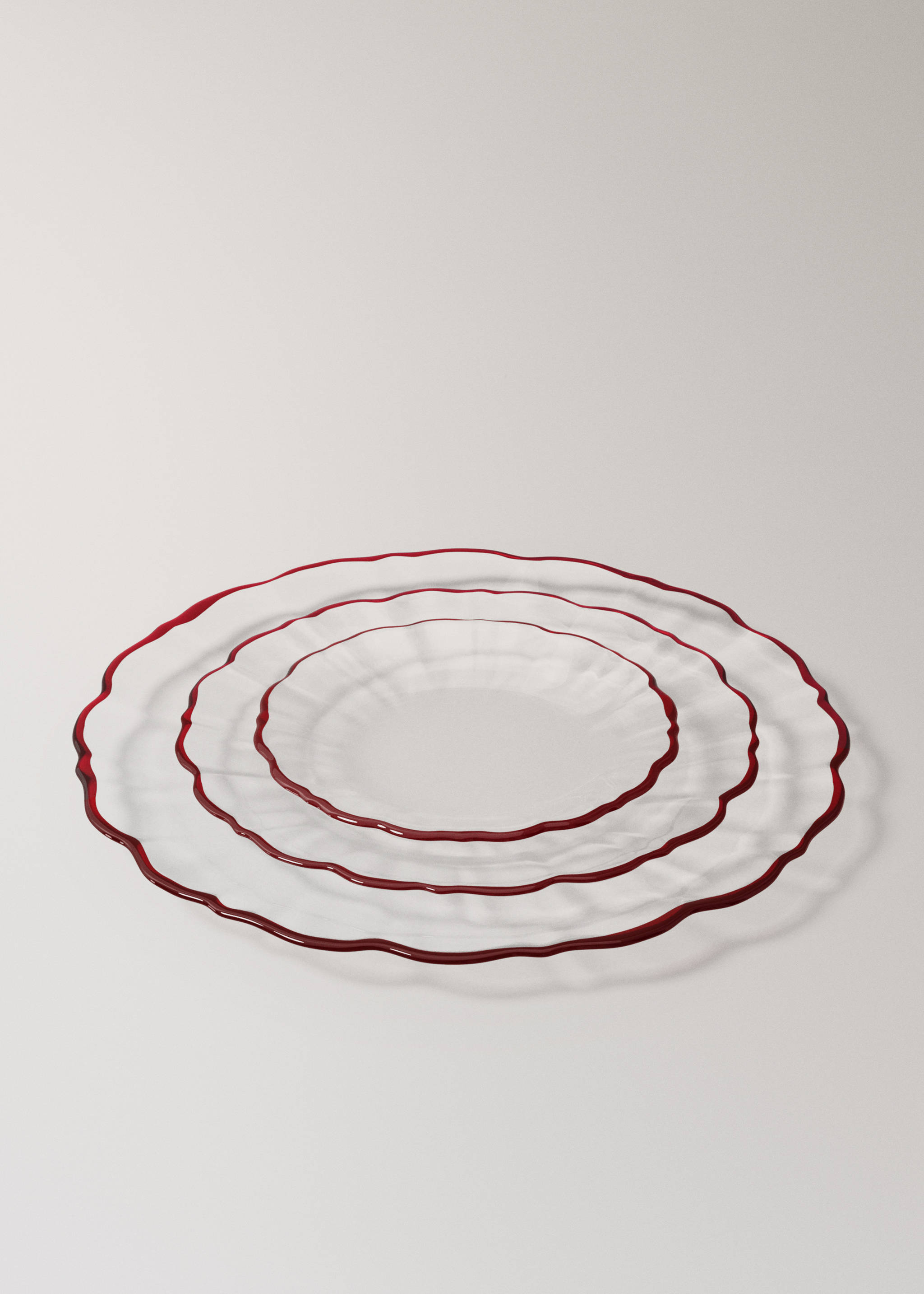 Transparent glass plates with irregular red rims.