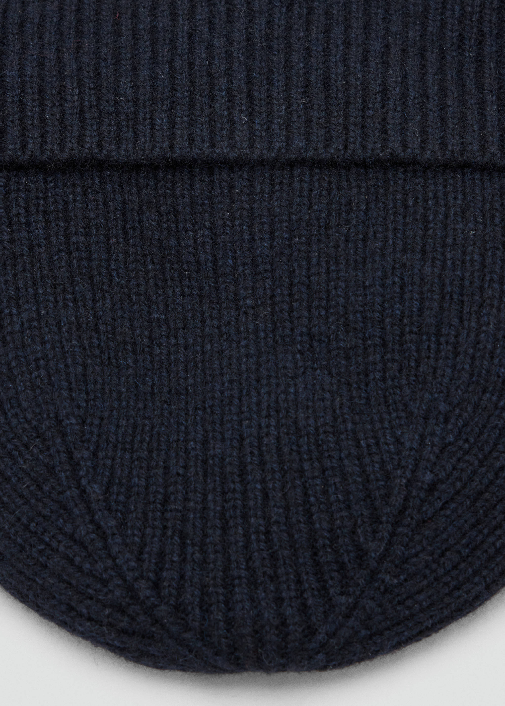 Close-up of a navy blue ribbed knit beanie.