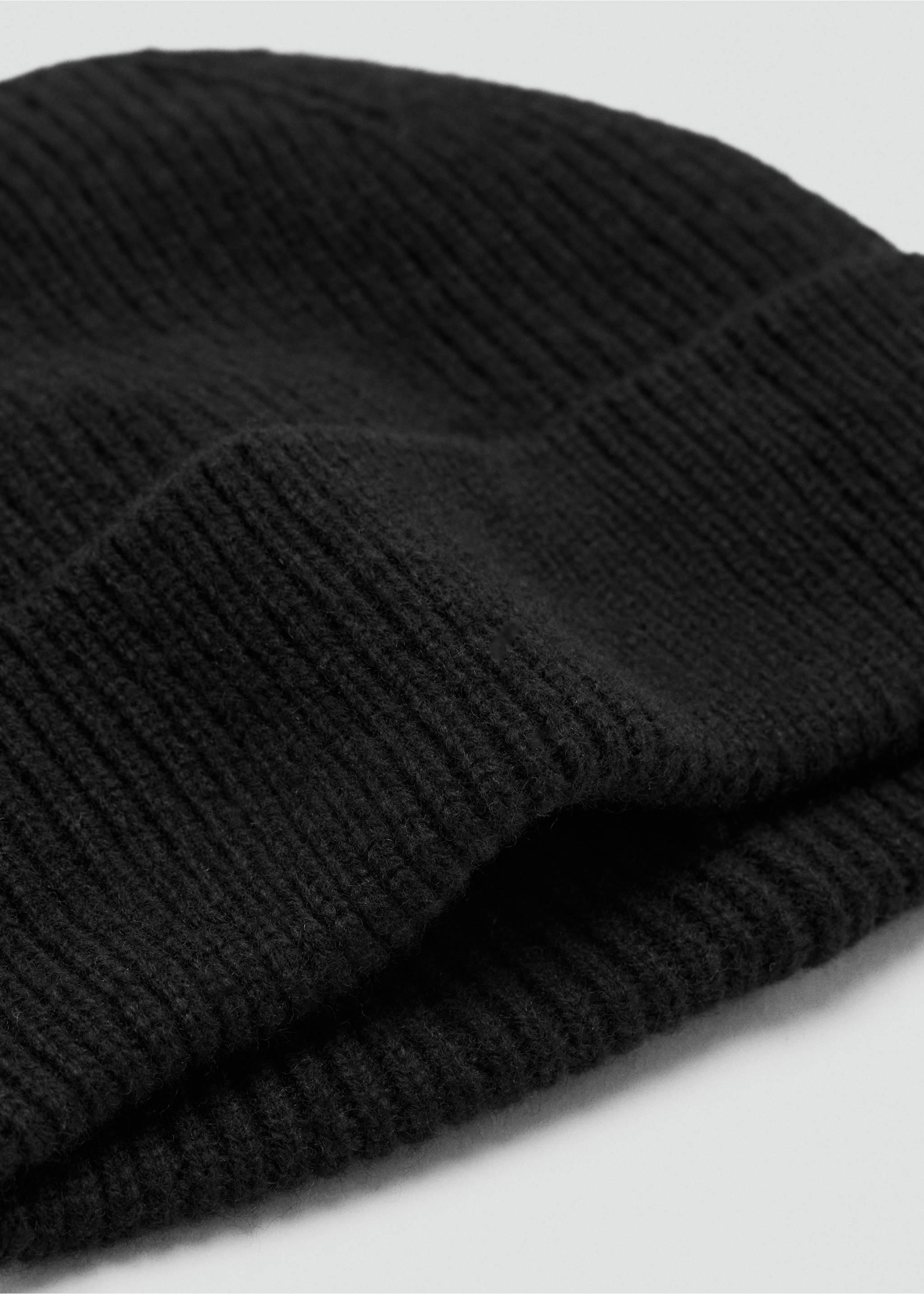 Black knitted beanie with a ribbed texture and folded brim in a three-quarter close-up., Black. Ref: 37047903-00.