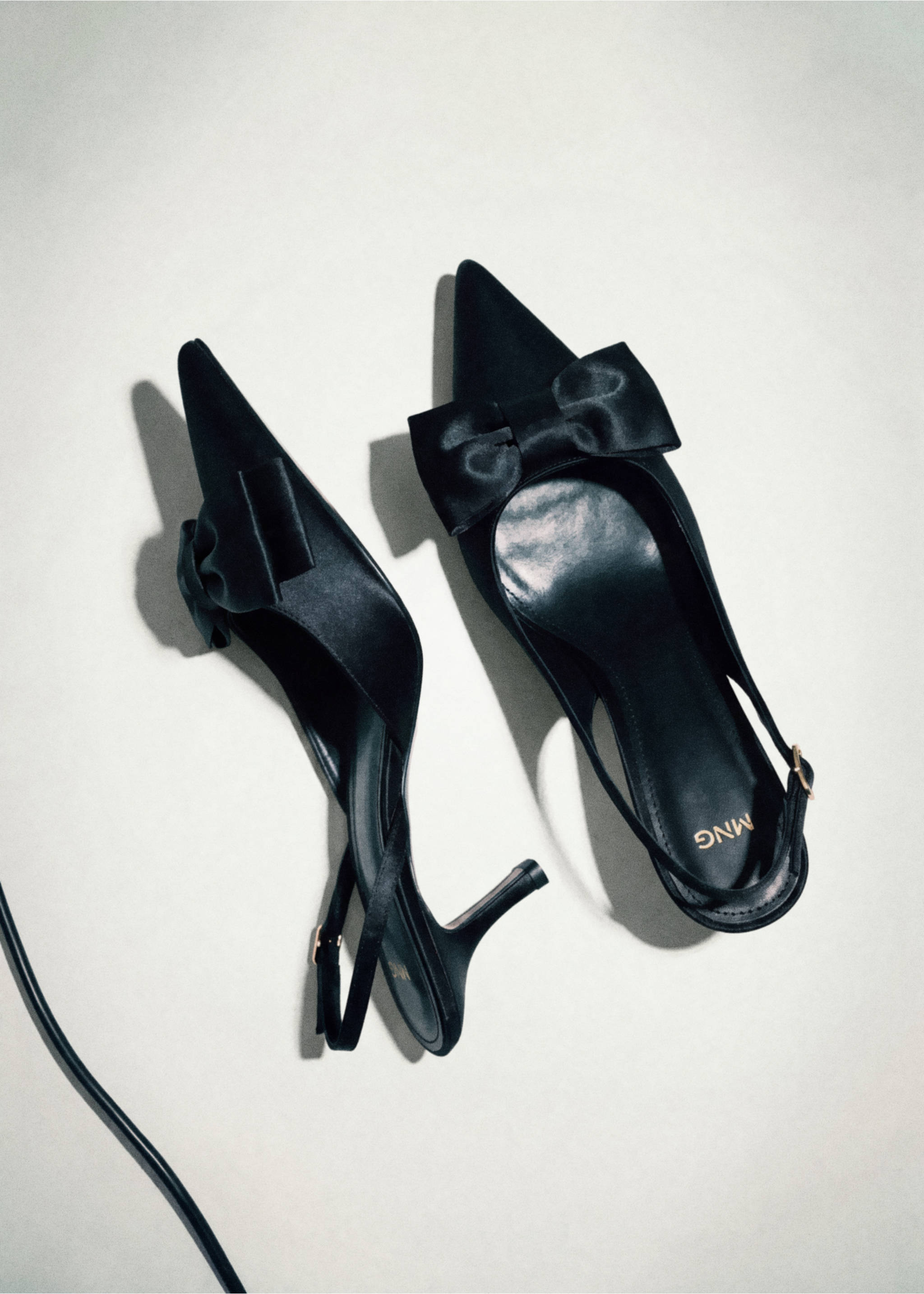 Black satin slingback shoes with a pointed toe and decorative front bow., Black. Ref: 37047914-00.