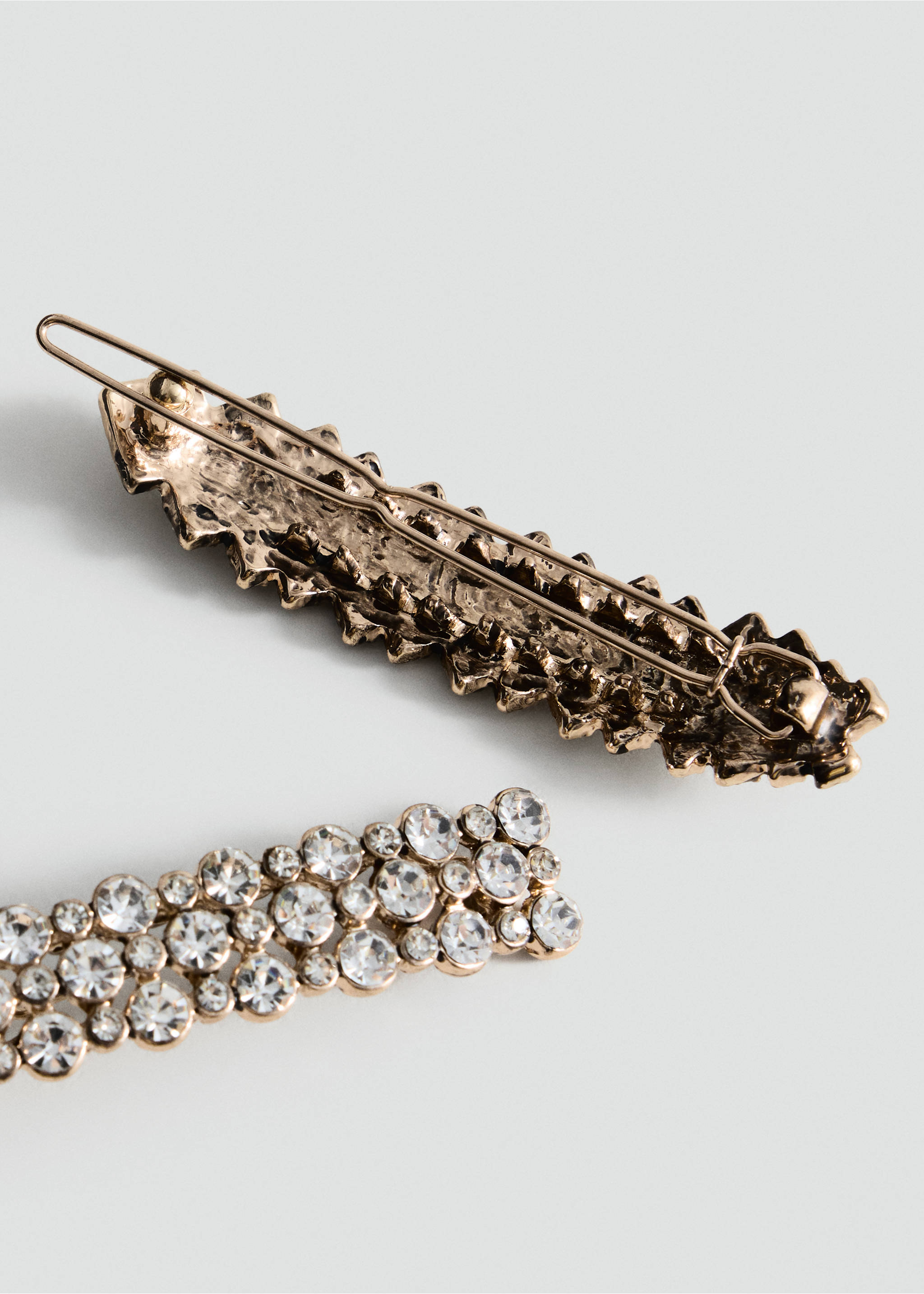 Gold-toned hair clip embellished with multi-sized clear rhinestones in a detailed three-quarters view., Gold. Ref: 37047915-00.