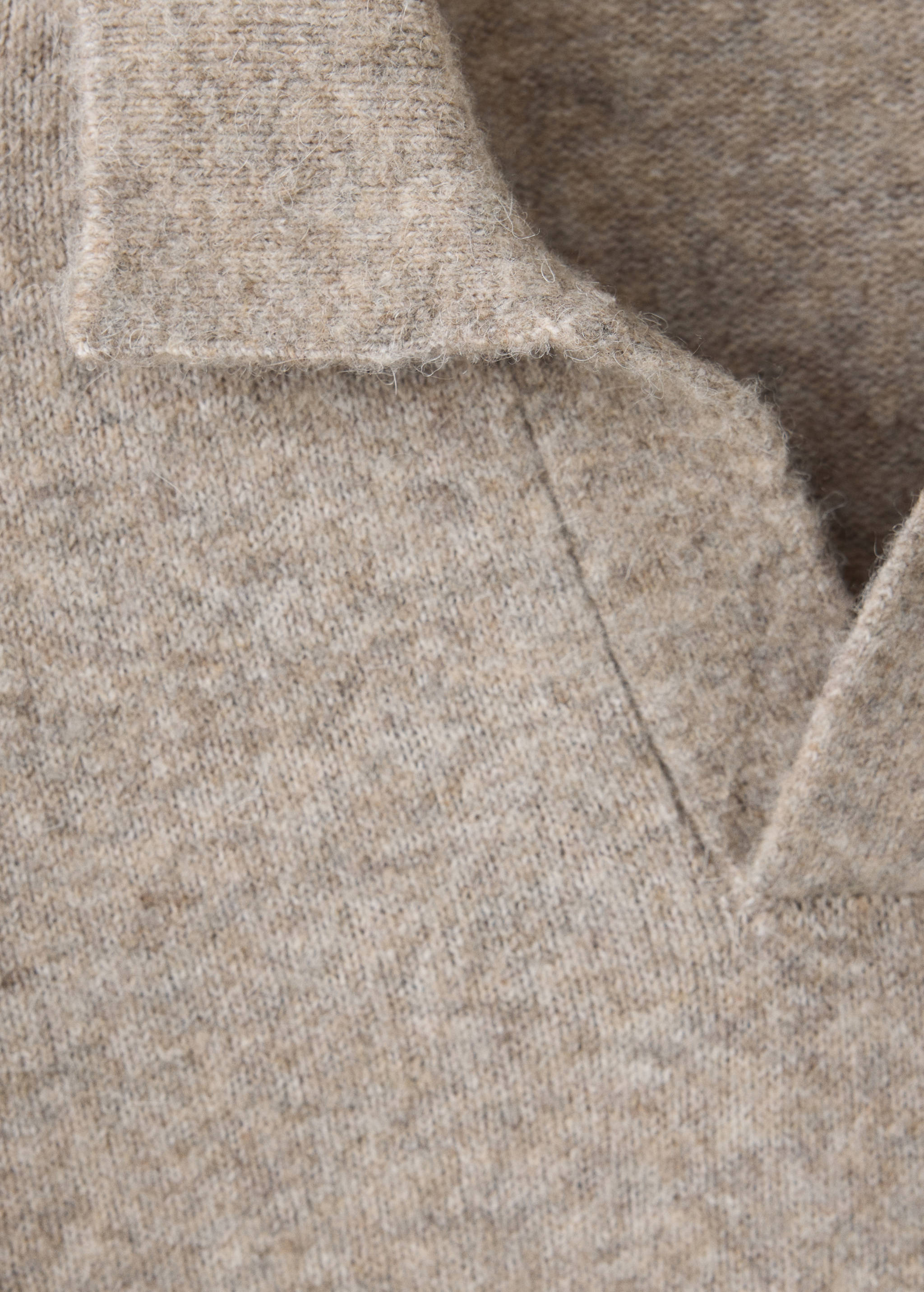 Close-up of a beige knitted polo collar and V-neck.