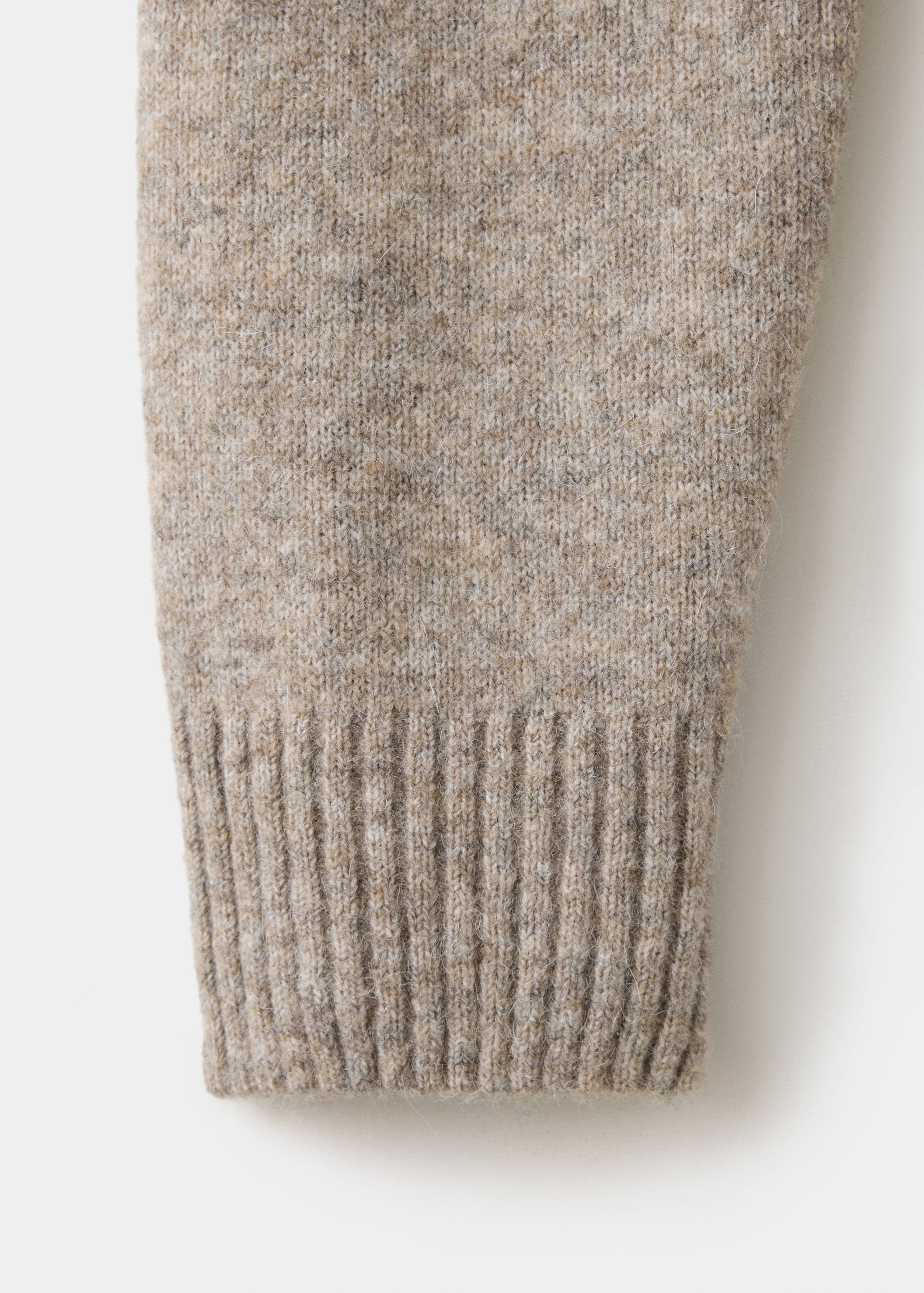Close-up of the ribbed cuff and textured melange beige knit of a men's polo.