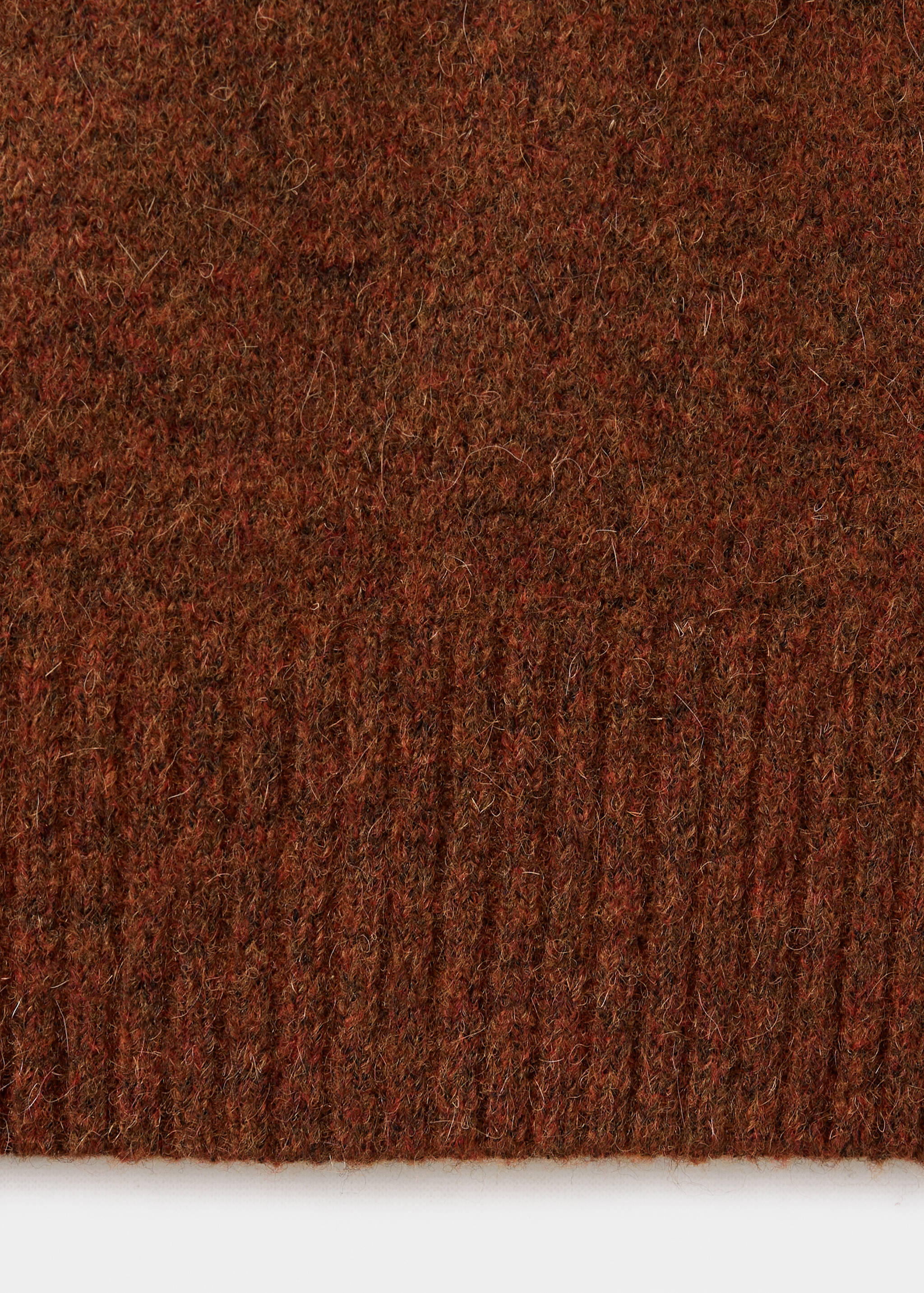 Brown knit polo fabric close-up with texture detail.