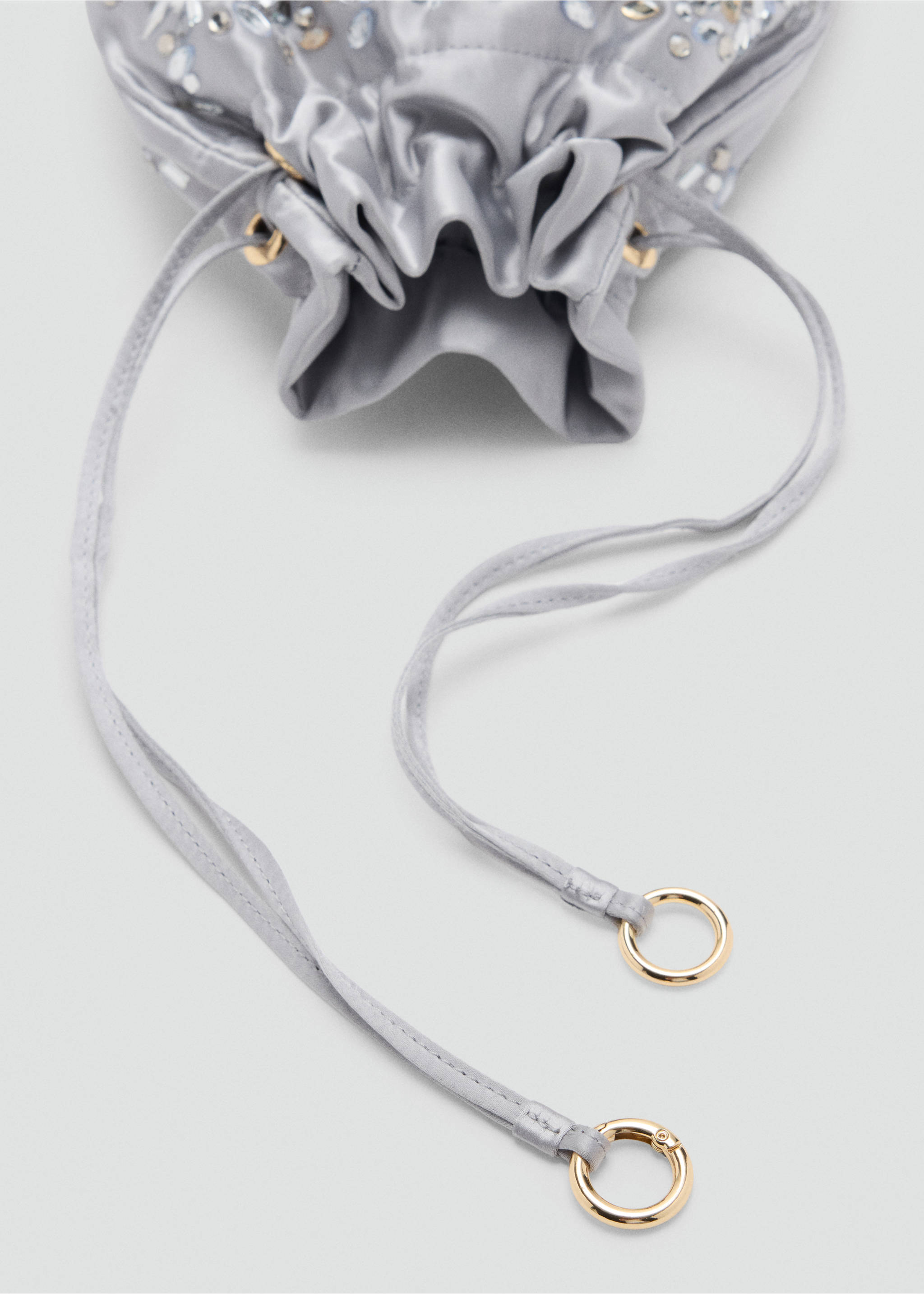 Close-up of a grey satin handbag with a drawstring closure and rhinestone embellishments., Light/Pastel Grey. Ref: 37047924-00.