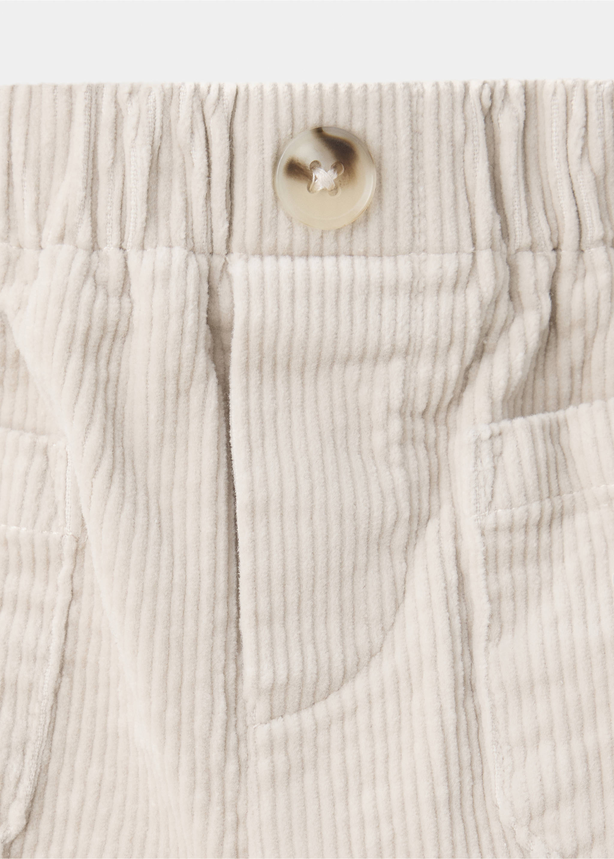 Close-up of beige corduroy trousers with an elasticated waistband, button closure, and front patch pockets., Beige. Ref: 37047927-00.