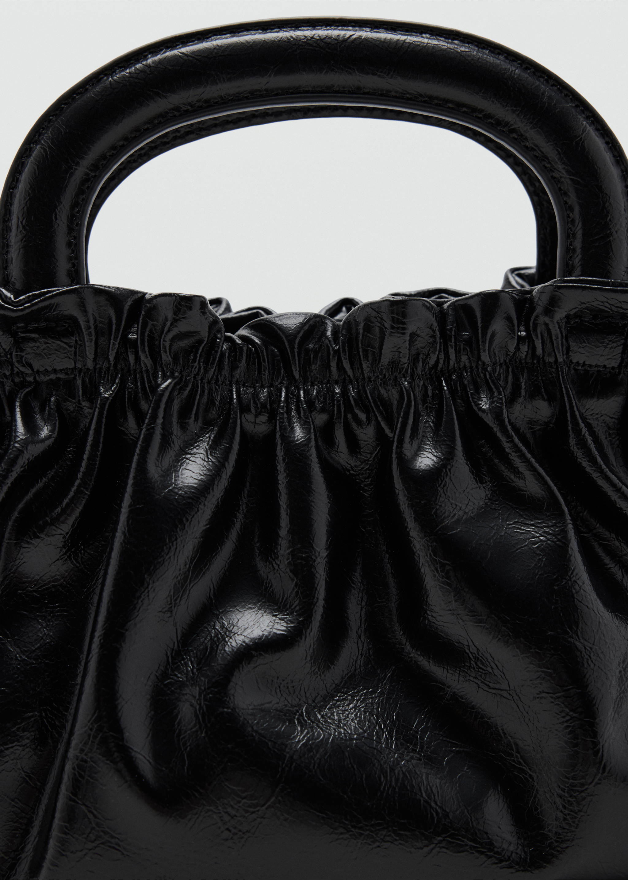 Close-up of a glossy black mini bag with a rigid top handle and gathered detail., Black. Ref: 37047931-00.