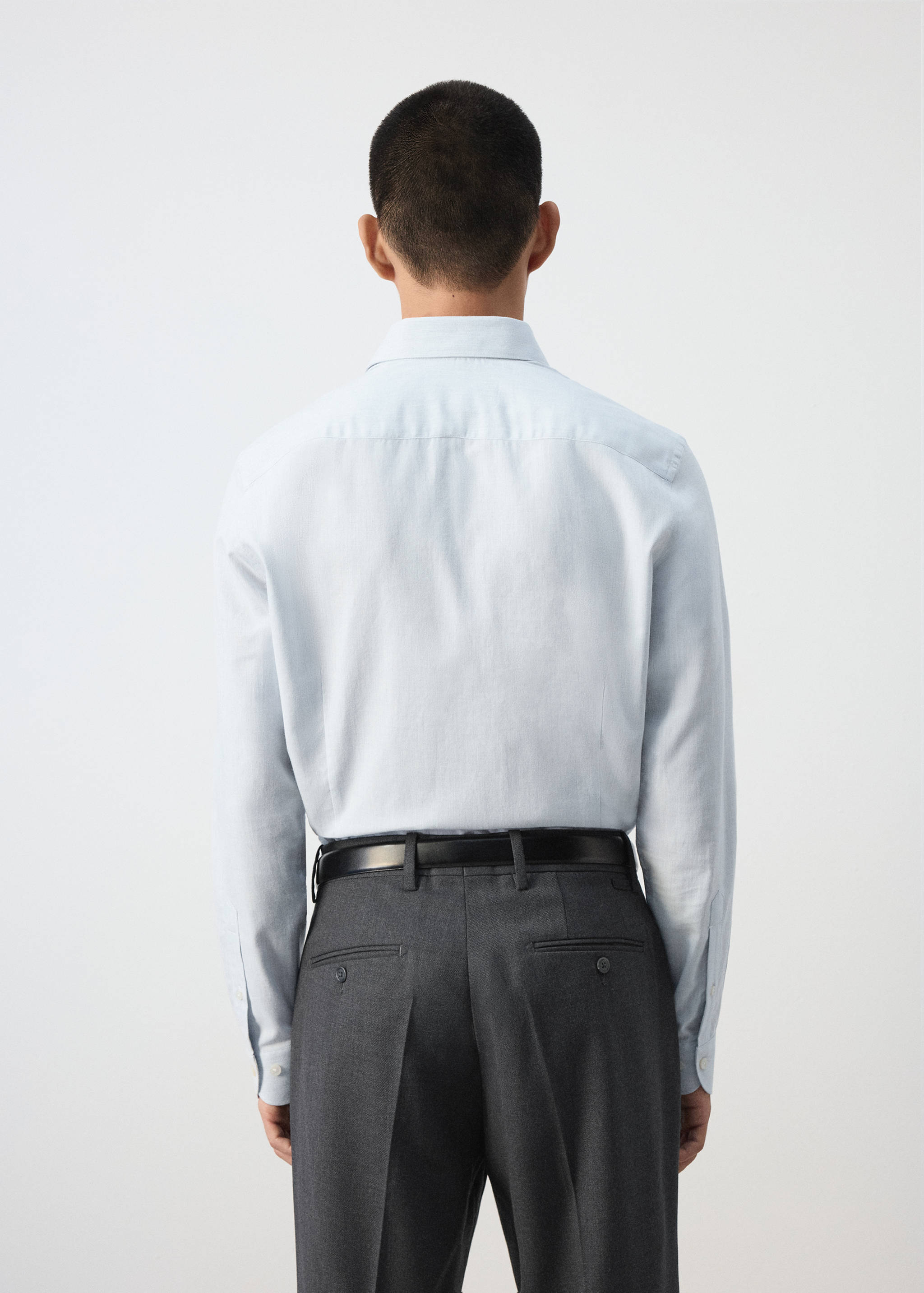 Back view of a light blue long-sleeved shirt with a classic collar.