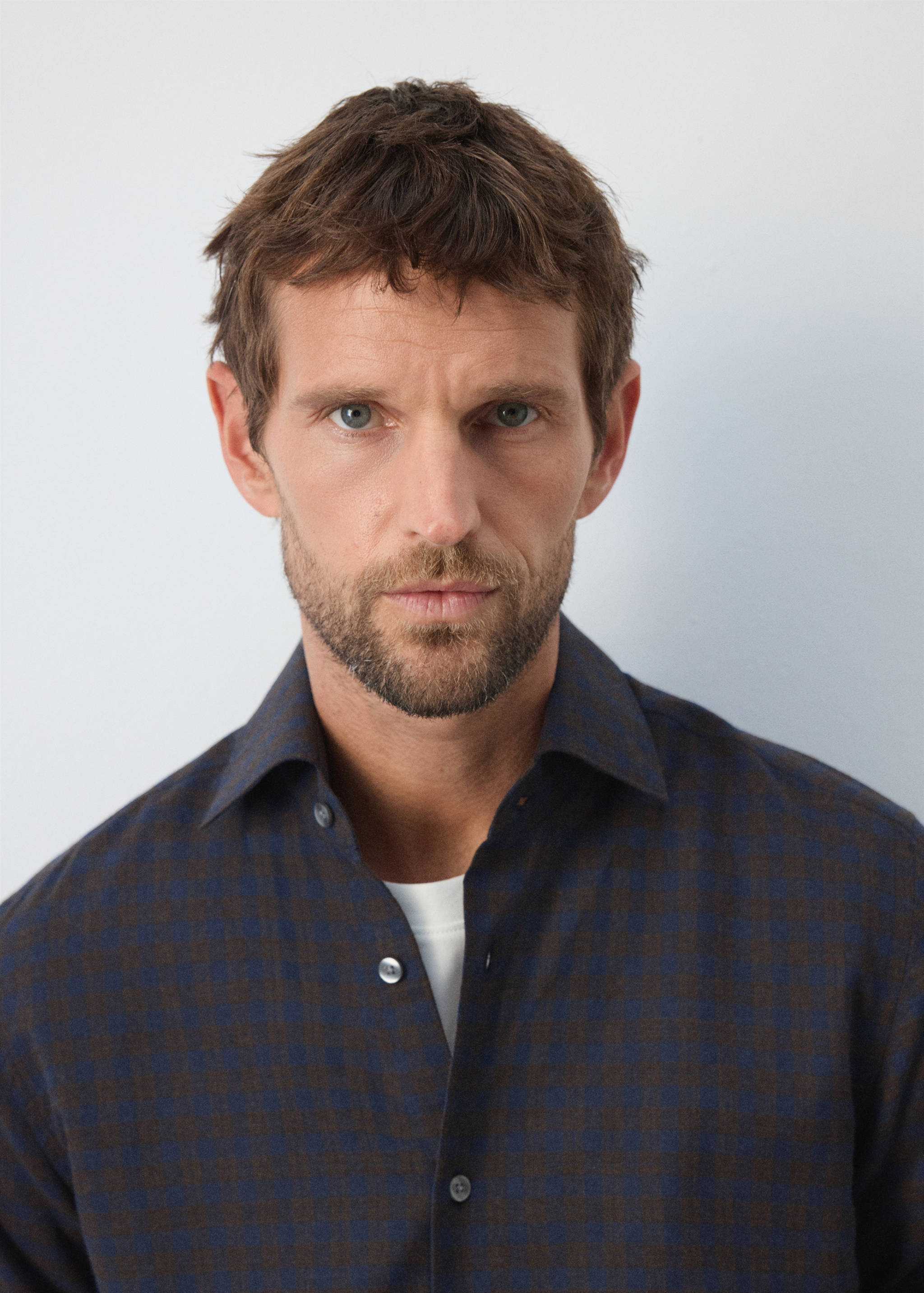 Close-up of a blue and brown checked shirt with a classic collar.