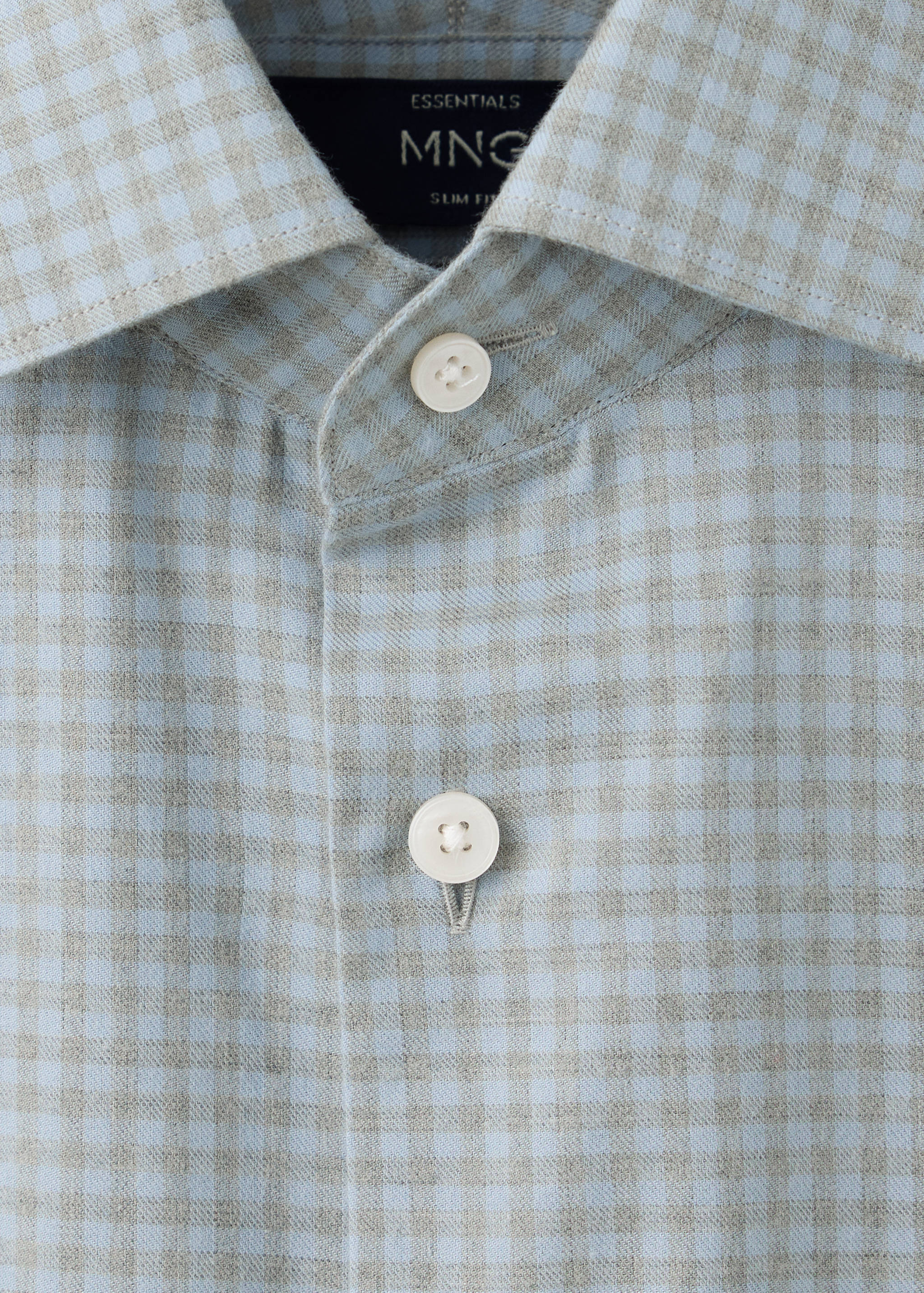 Close-up of a light blue and beige checked shirt collar and placket detail.