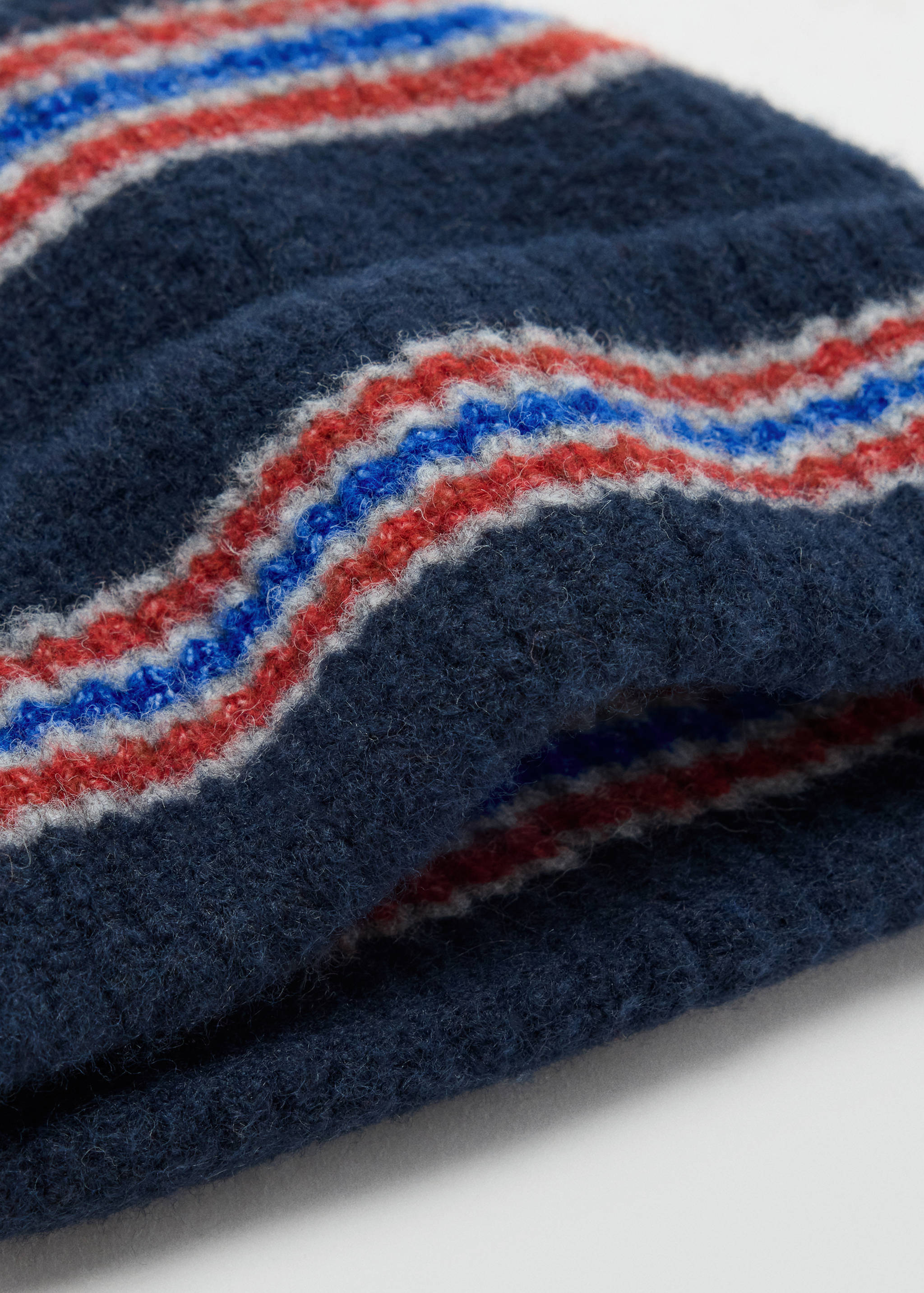 Navy blue knitted hat with a fuzzy texture and horizontal white, red, and blue stripes.