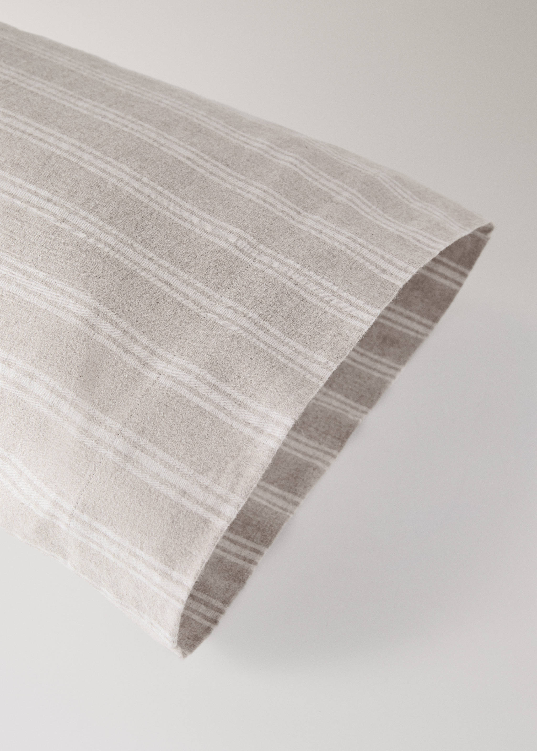 Close-up of a beige and white striped pillowcase.