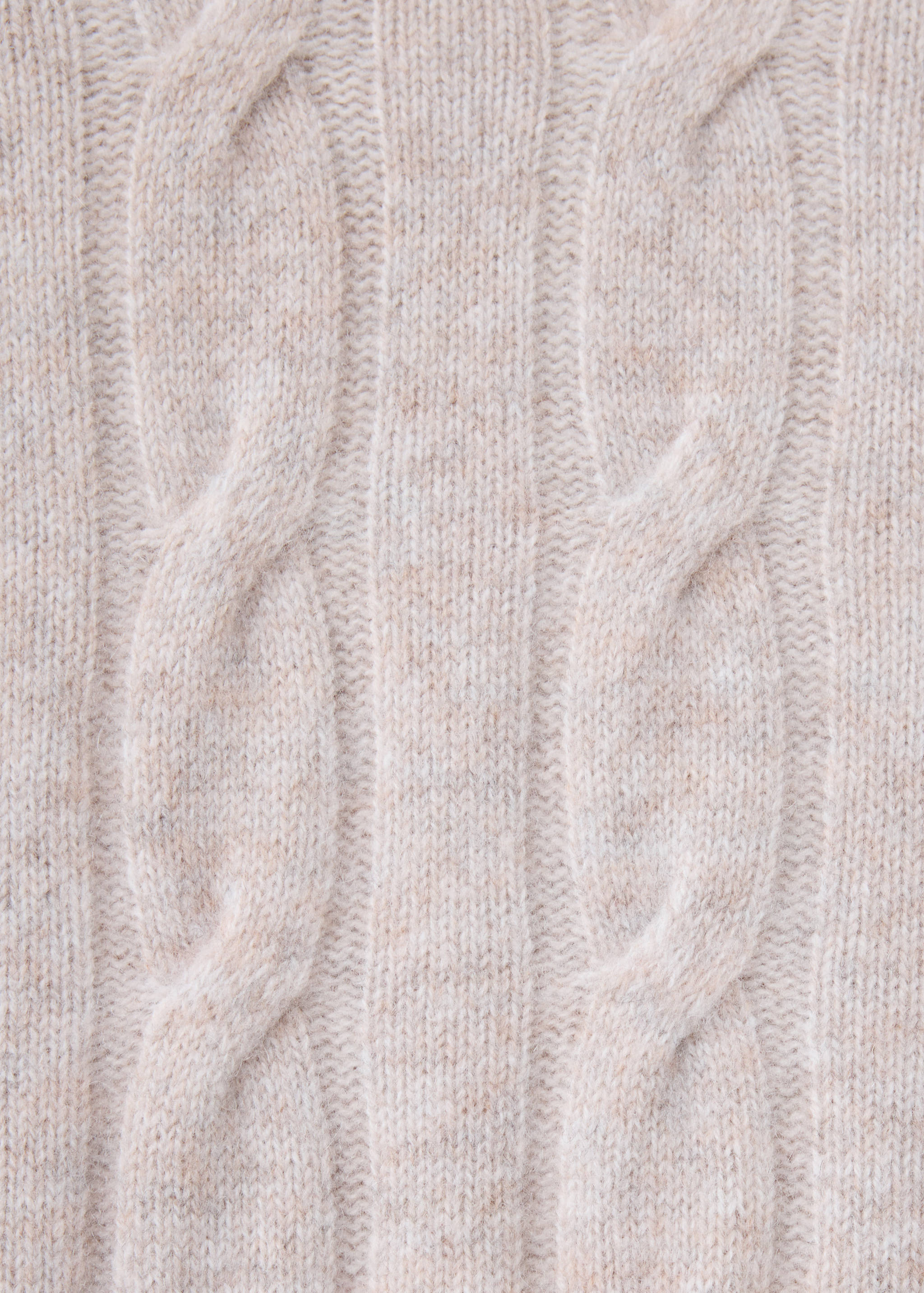 Close-up of a beige cable knit jersey fabric.
