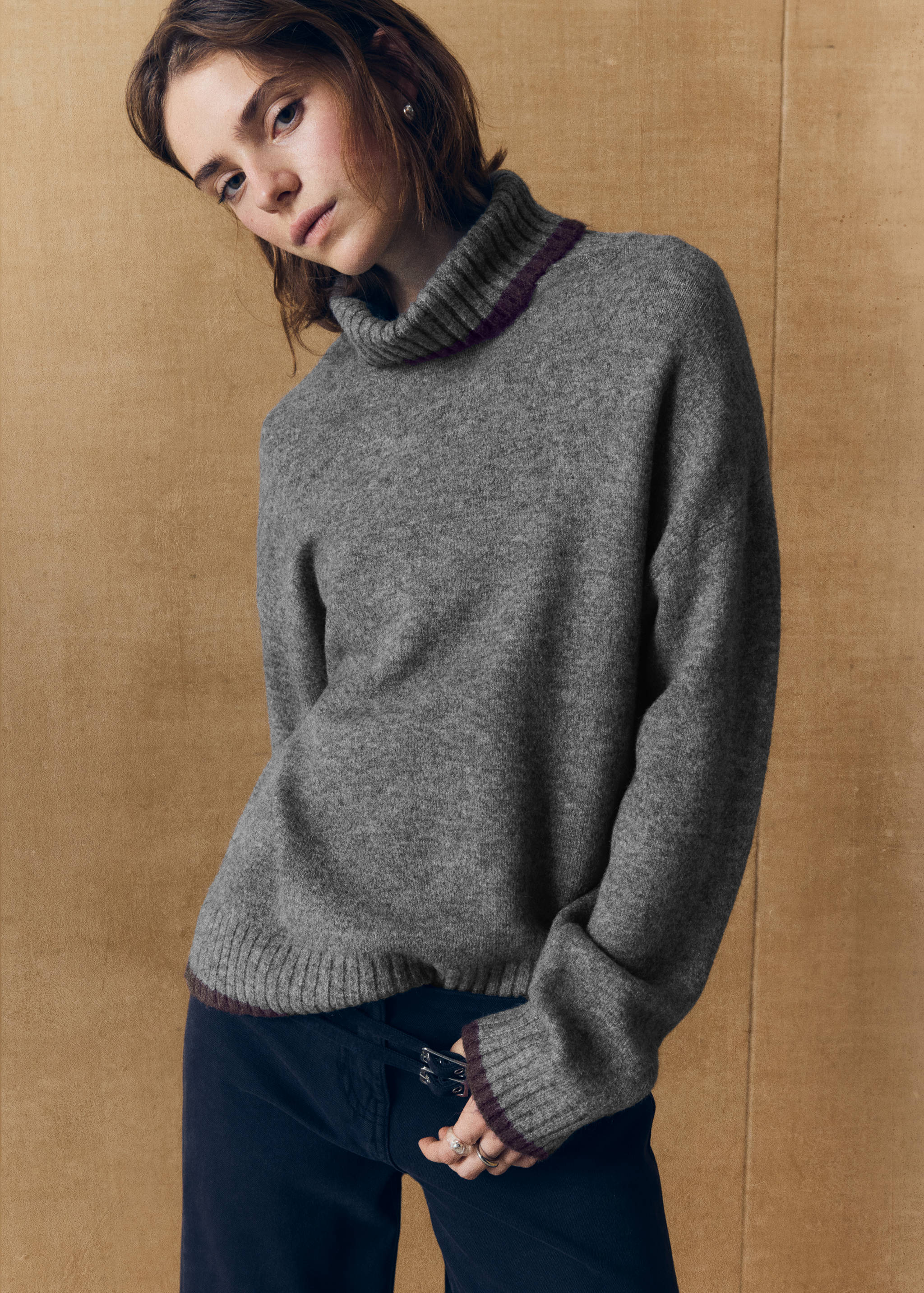 Grey turtleneck knit jersey with long sleeves and contrasting dark ribbed trim.