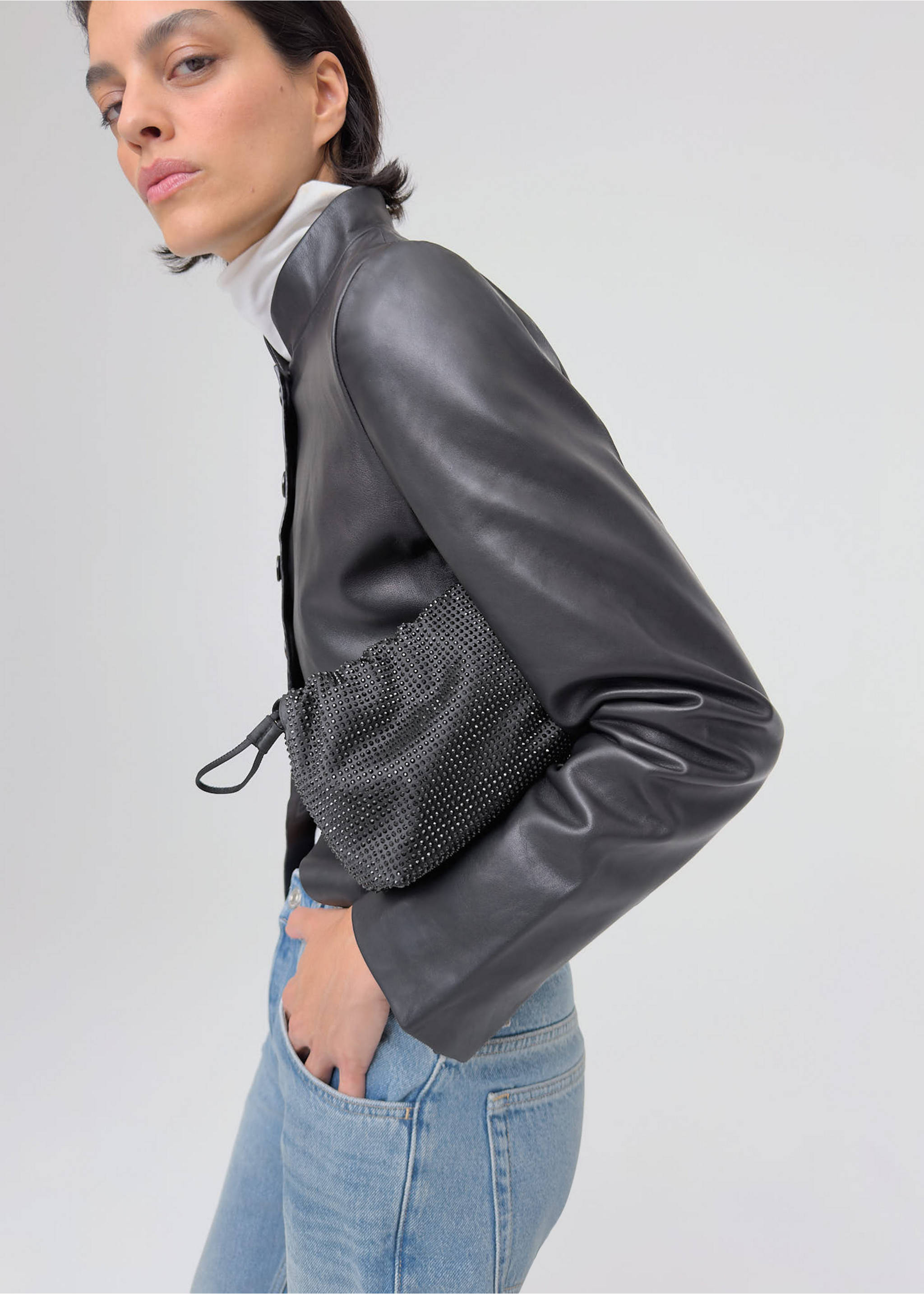 Black rhinestone-embellished shoulder bag with a gathered drawstring closure, worn by a model., Black. Ref: 37048279-00.