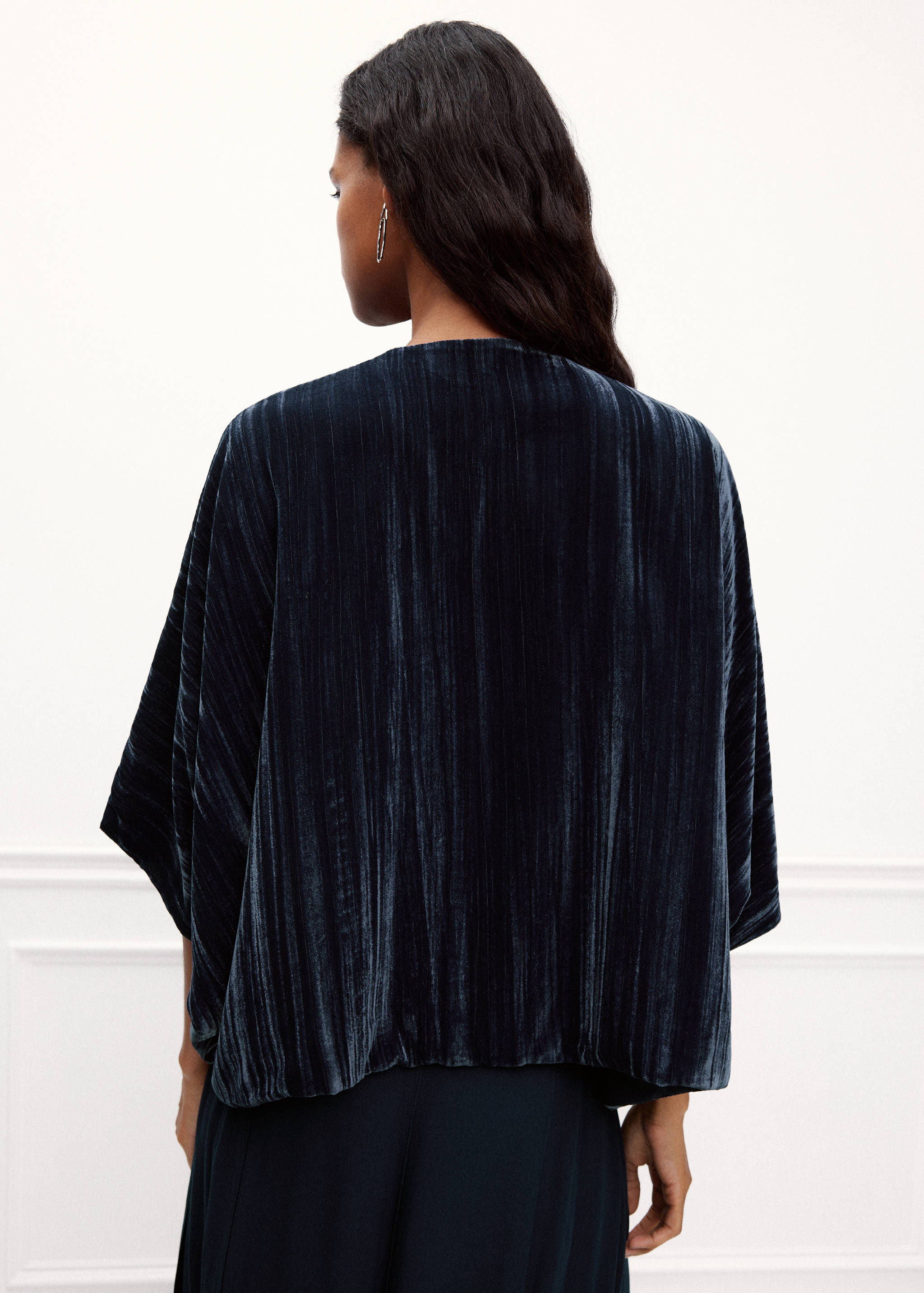 Dark blue velvet blazer shown from the back, with a relaxed fit and short wide sleeves.