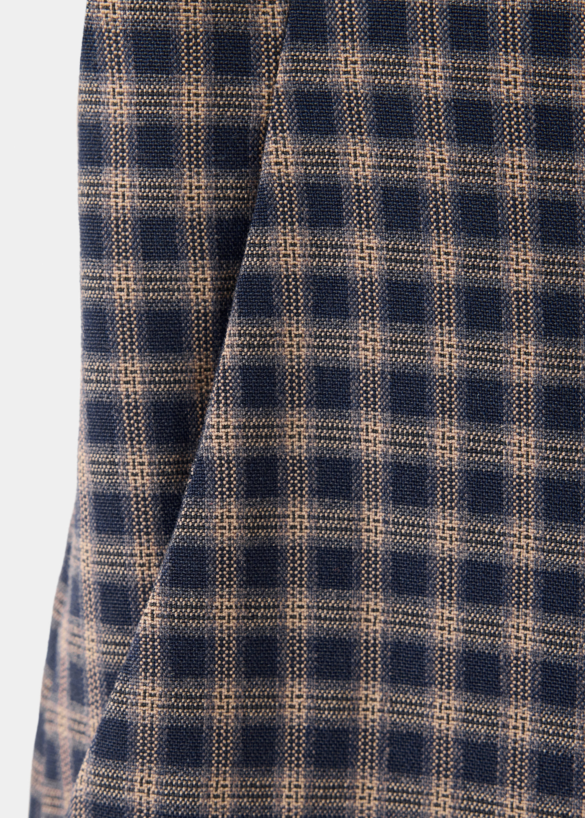 Close-up of children's trousers in a dark blue and brown check fabric.