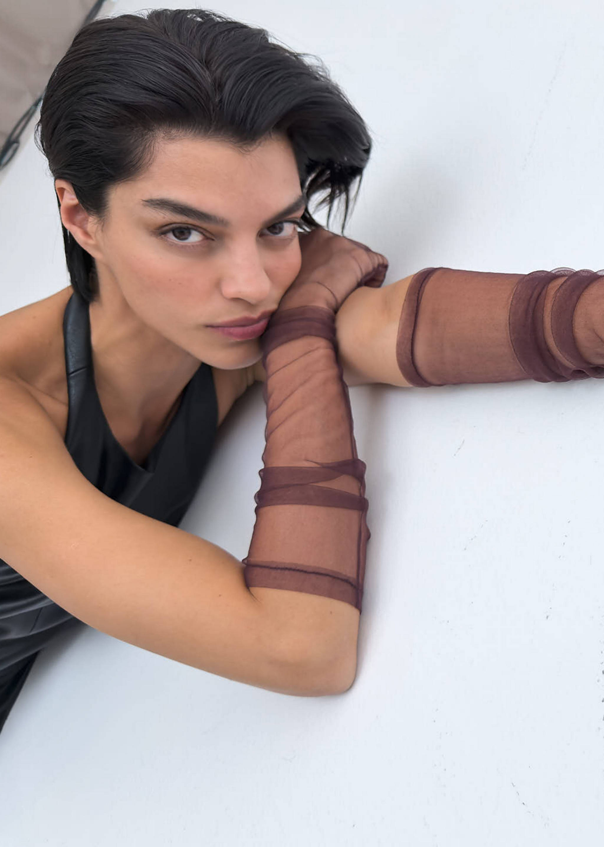 Sheer brown tulle gloves with gathered details reaching past the elbows.