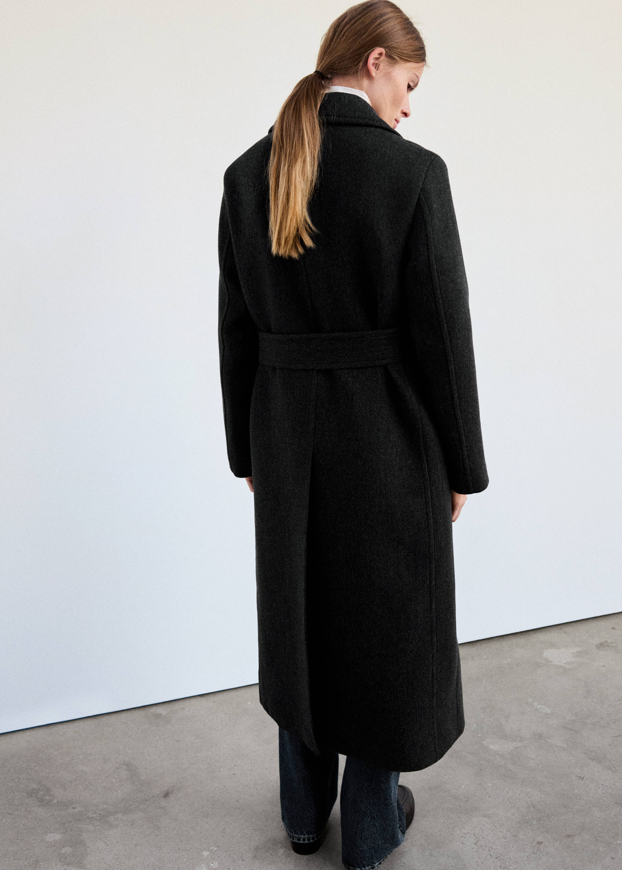 Dark grey belted long coat, back view