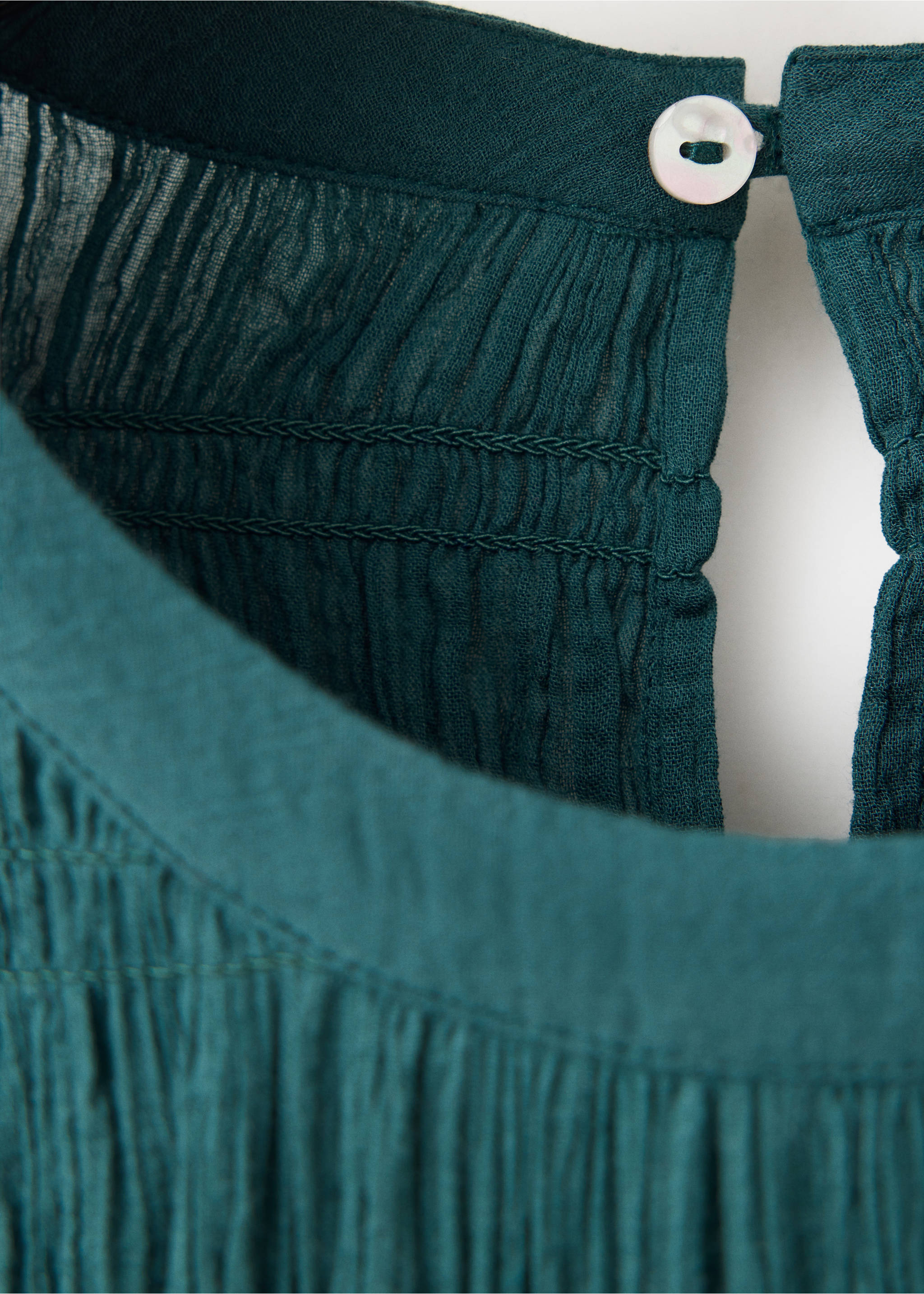 Detalle de blusa verde verdoso oscuro que muestra el tejido texturizado, la espalda nid de abeja y el cierre de botones., Azul petróleo. Ref: 37049116-00.