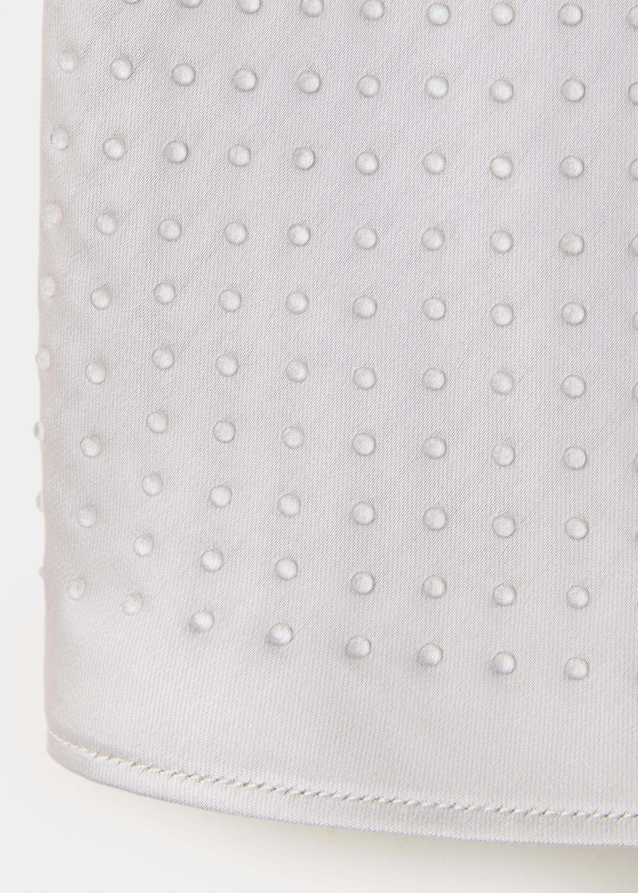Silver top detail featuring raised circular dots and a hem