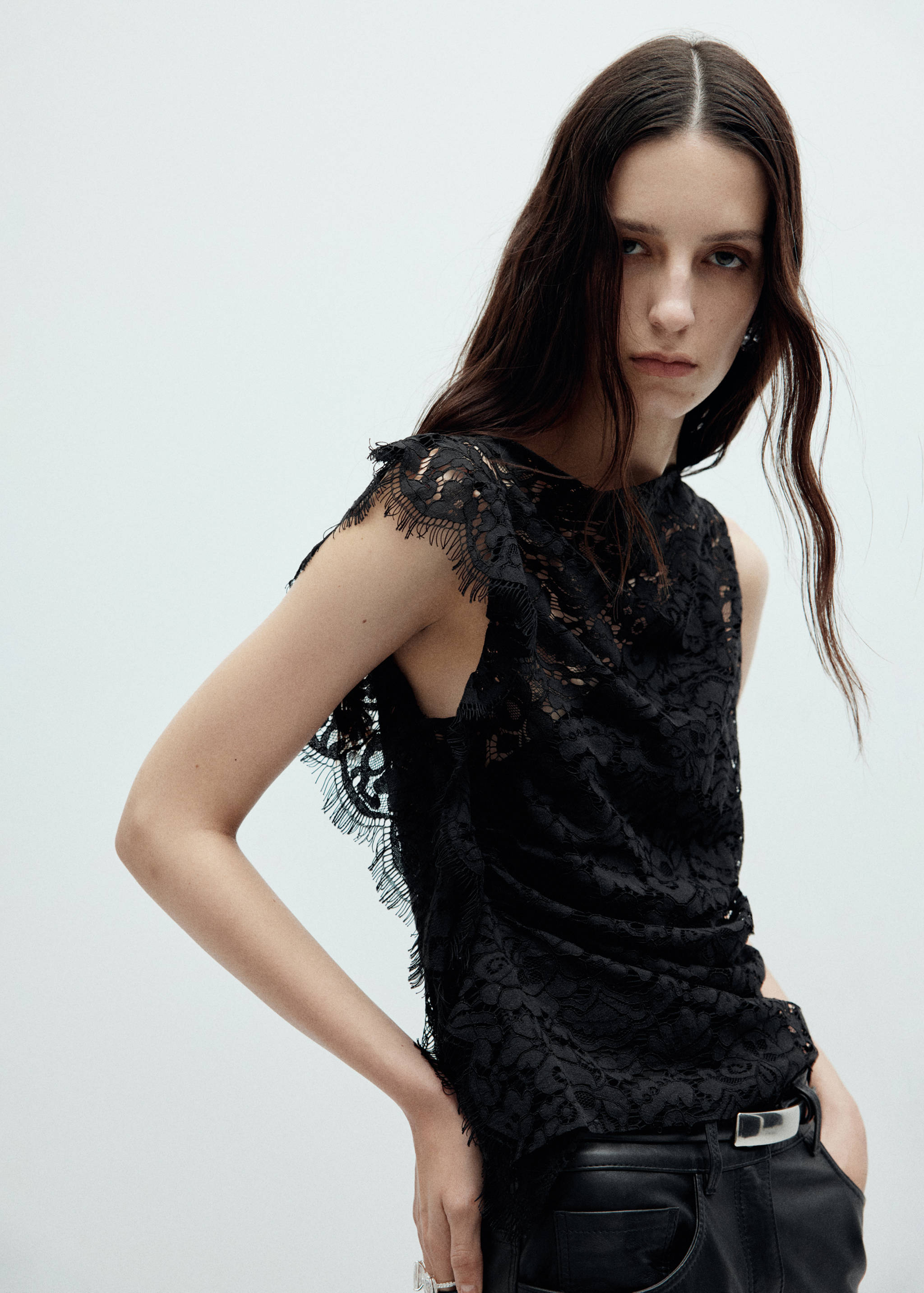 Black lace top with a round neck, sleeveless shoulders and fringed lace trims.
