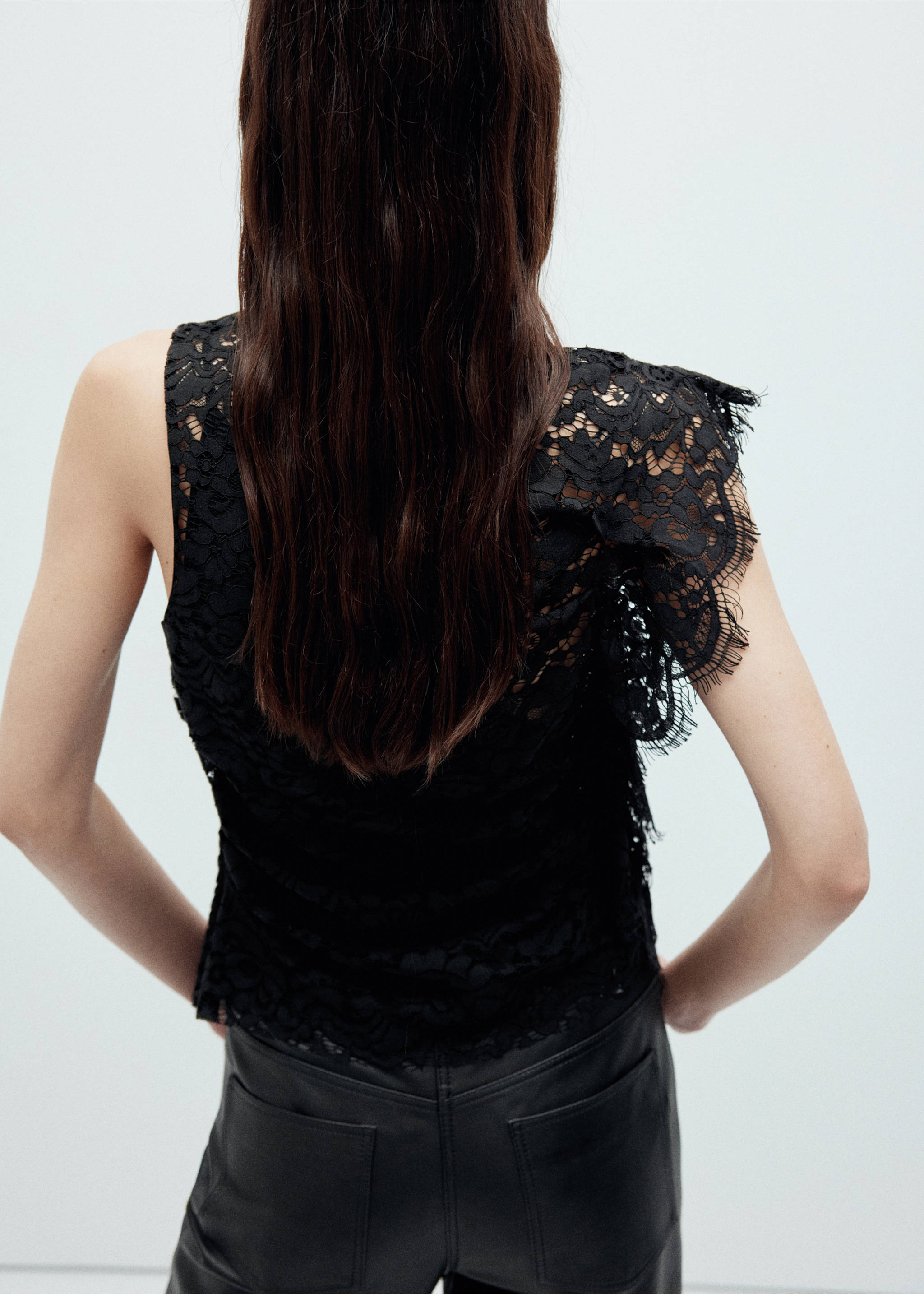Black lace top with a sleeveless cut and ruffled shoulder, shown from the back., Black. Ref: 37049122-00.