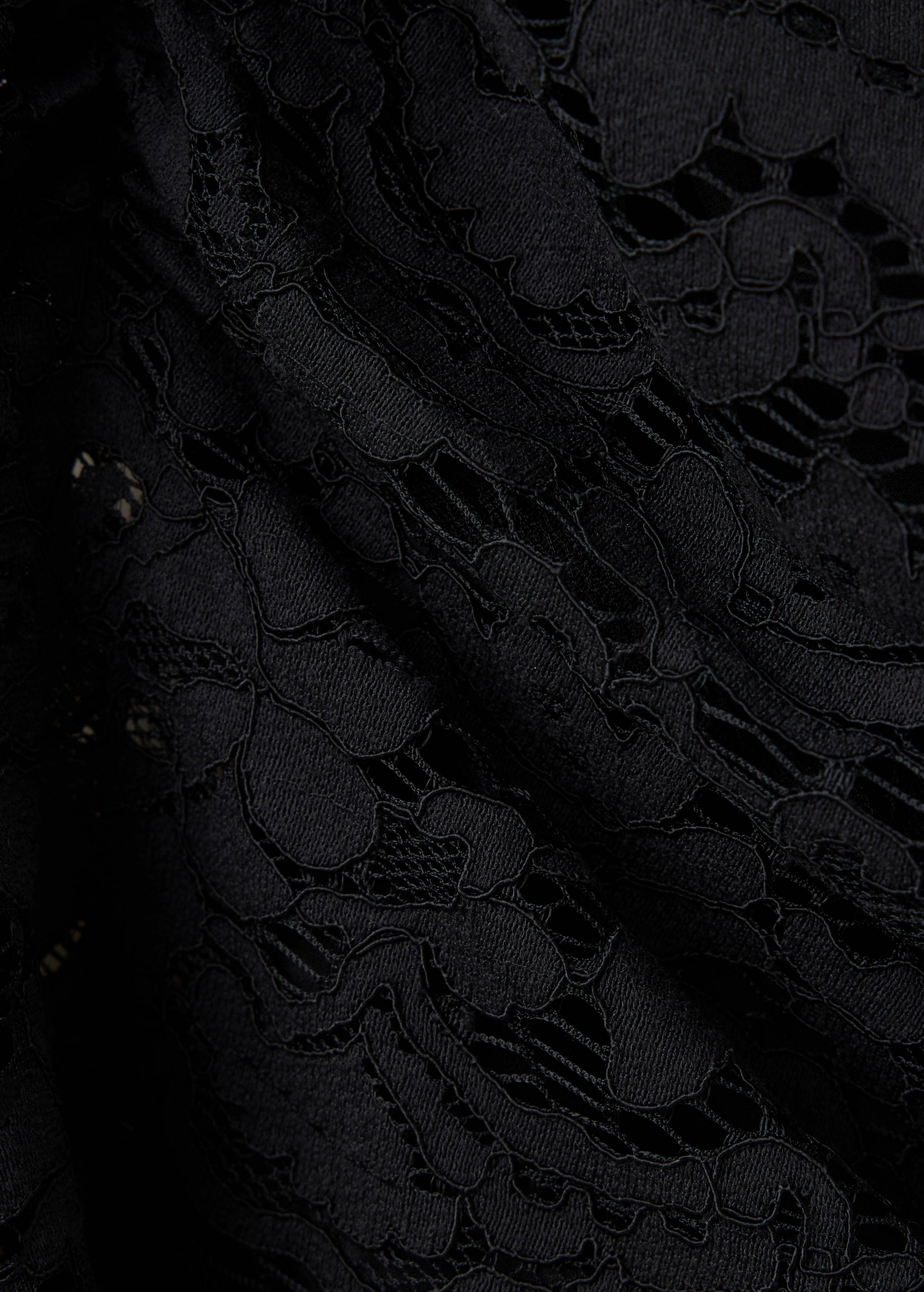 Close-up of a black lace top showing the intricate floral pattern.
