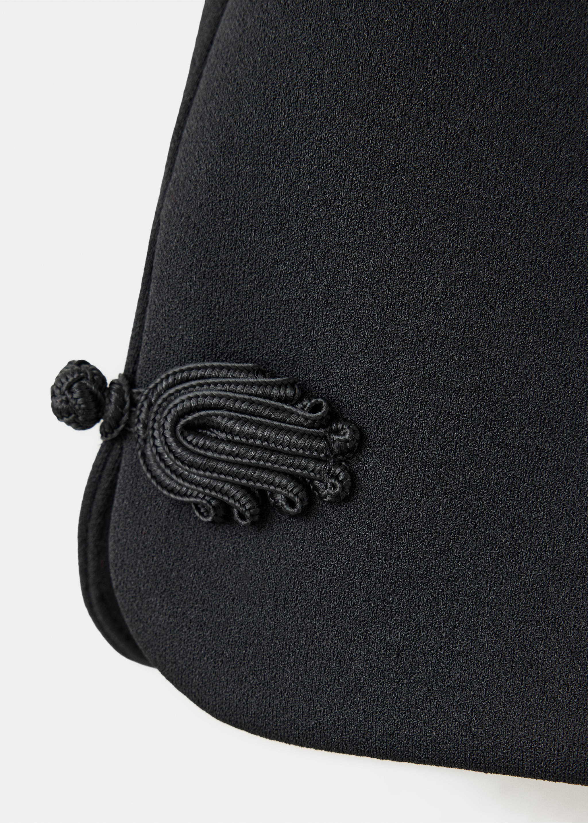 Close-up of black shorts with a decorative cord frog closure, Black. Ref: 37049123-00.