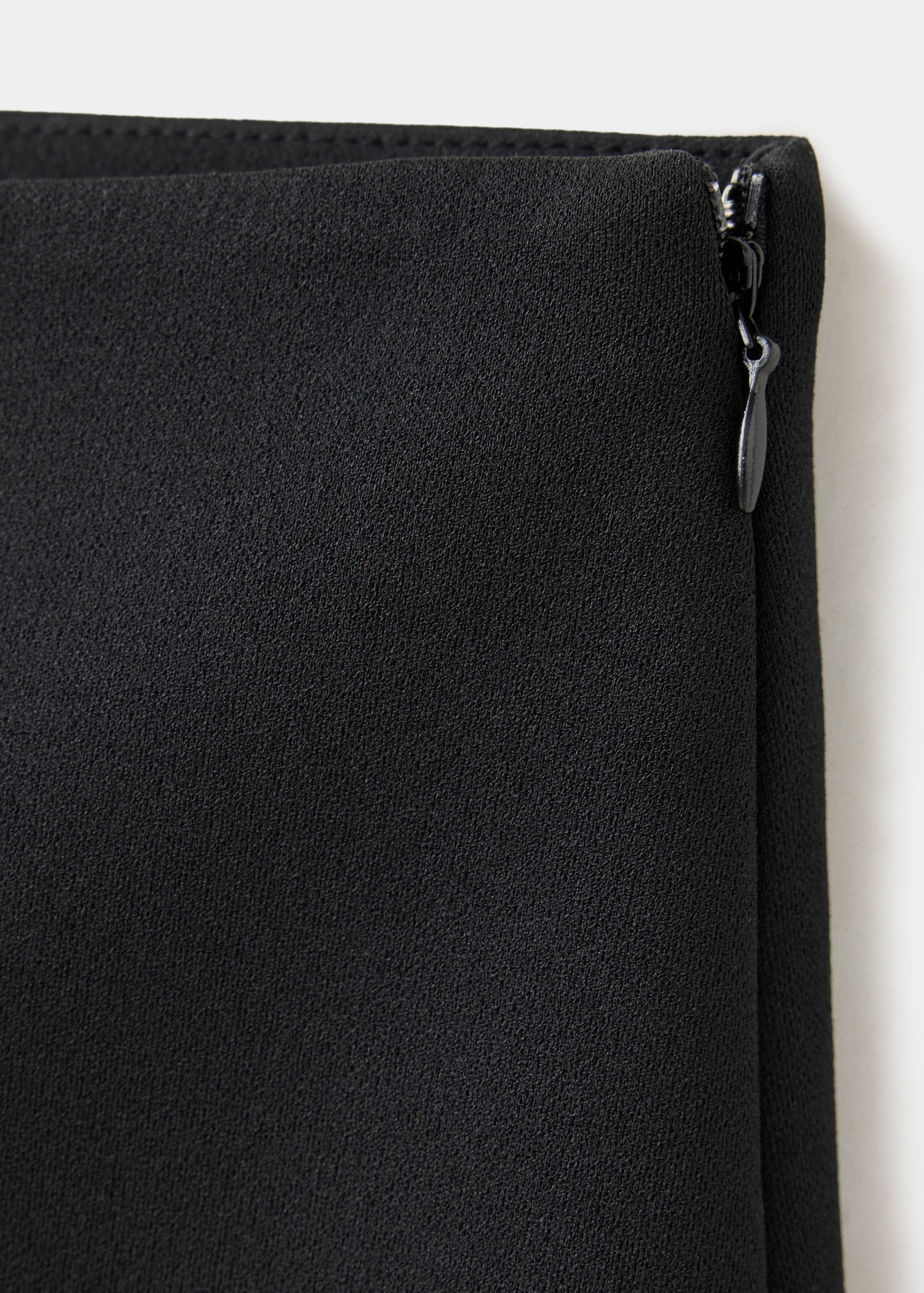 Close-up of black shorts fabric detail with a side zip.
