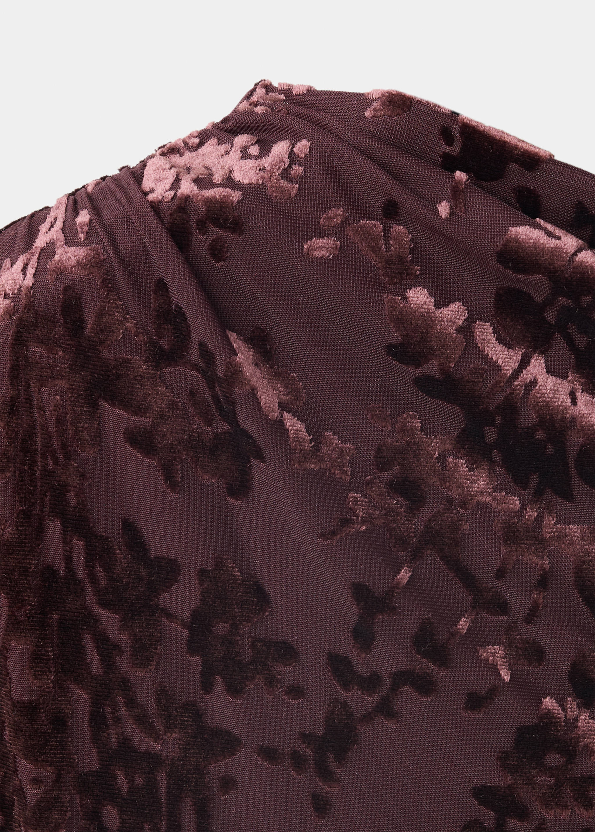 Detalle de vestido de terciopelo burdeos con estampado floral flocado.
