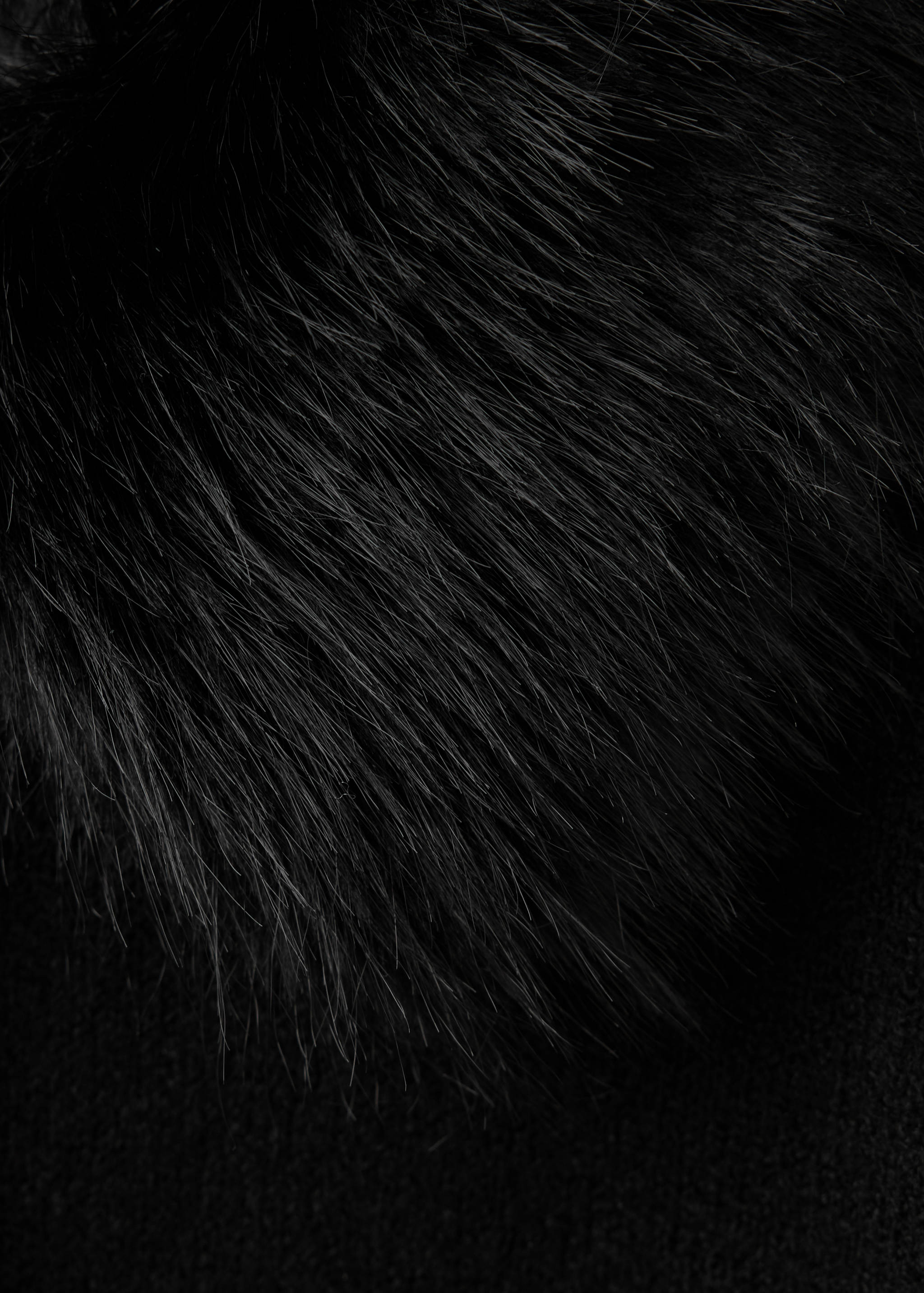 Close-up of black faux-fur cardigan fabric detail.
