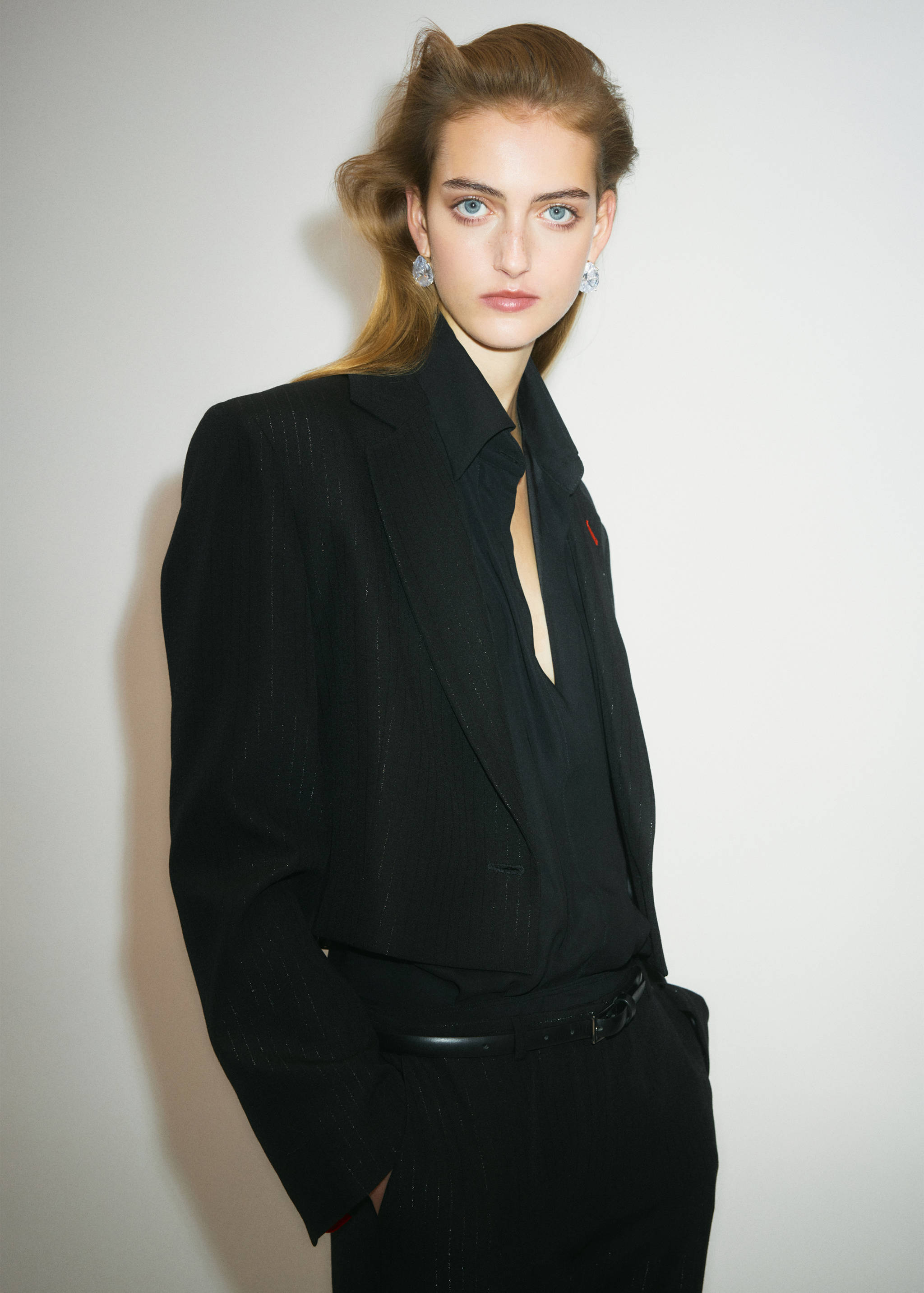 Black tailored pinstripe blazer with lapels and single-button closure.