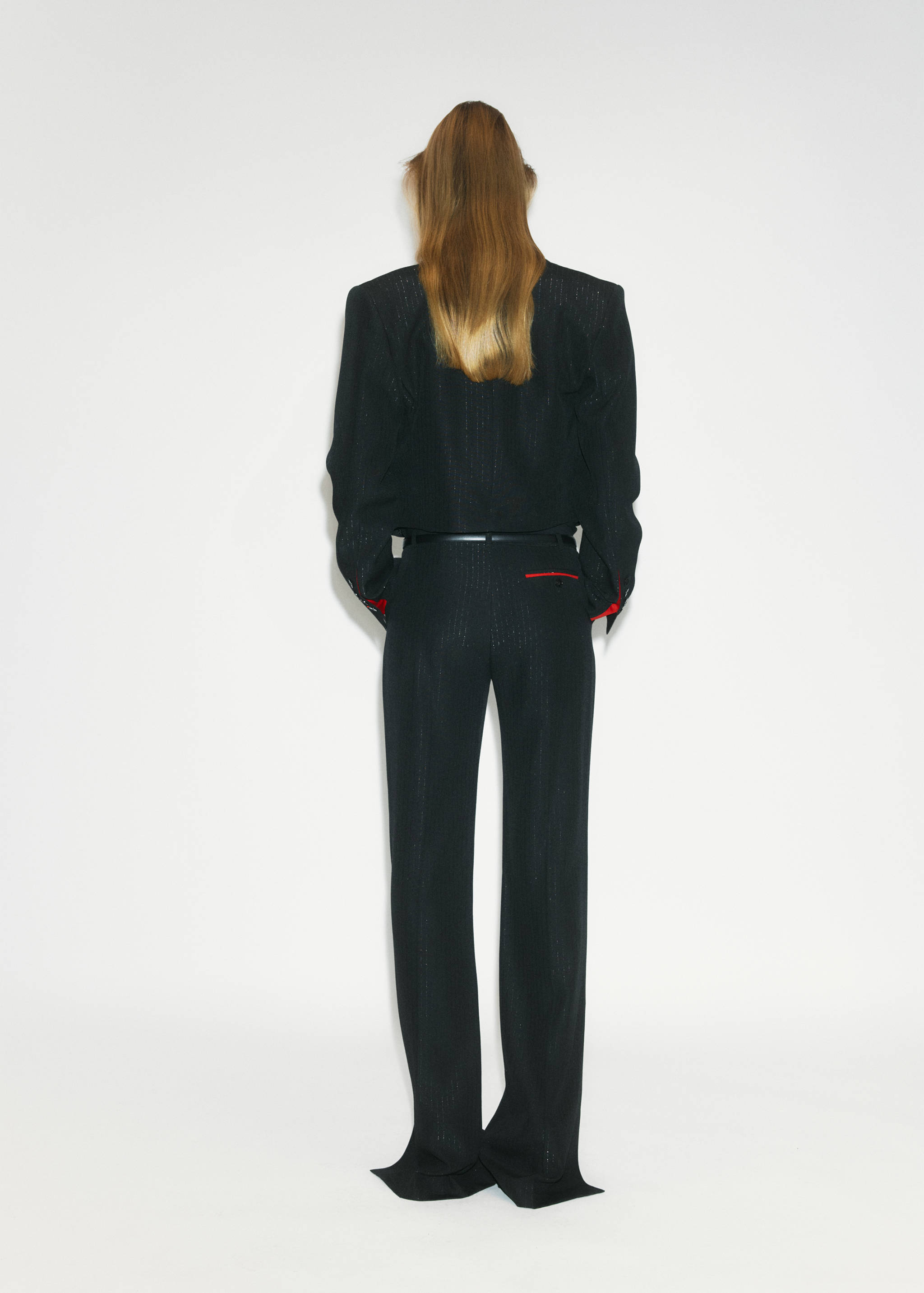 Back view of a black structured blazer with padded shoulders and matching trousers.