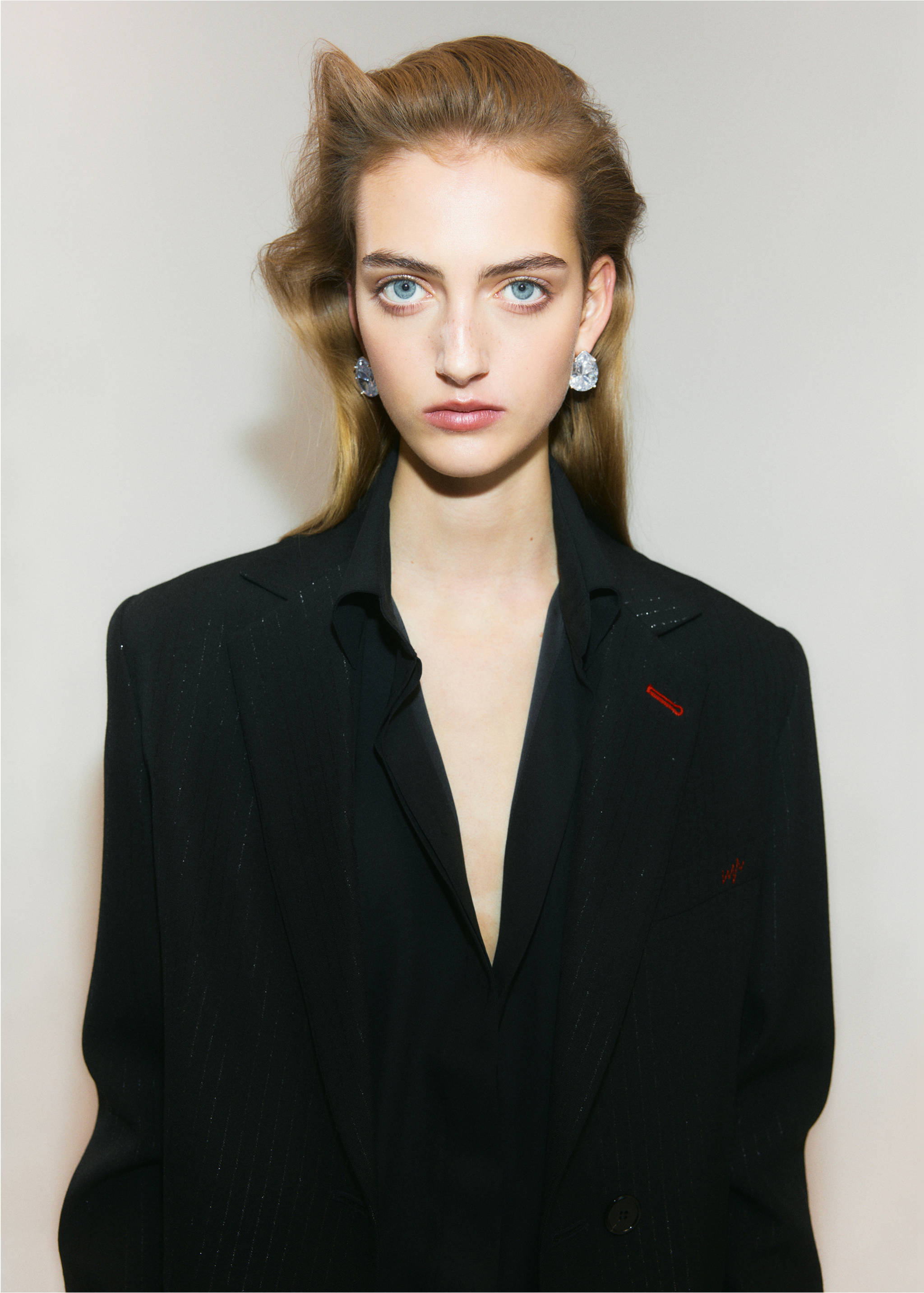 Close-up of a black blazer with a red embroidered lapel detail, worn by a model., Black. Ref: 37049144-00.