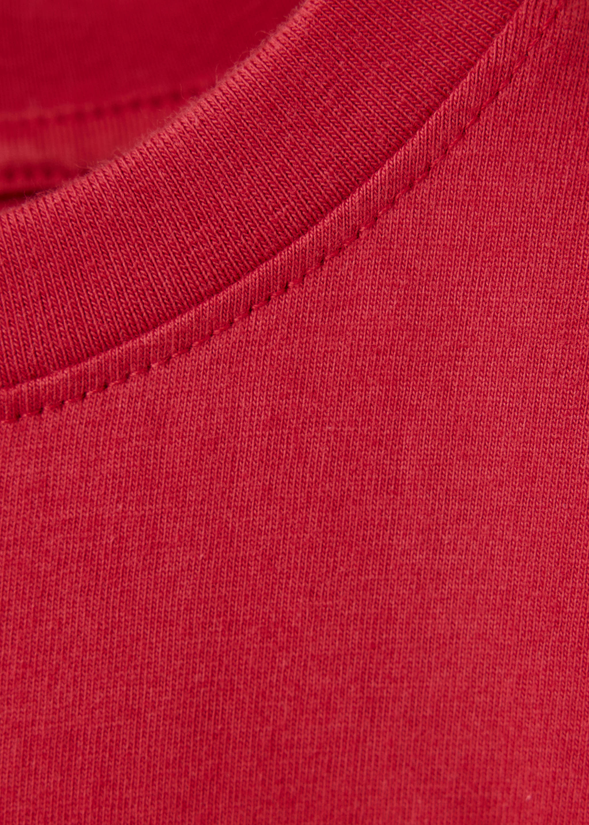 Close-up of the red t-shirt's ribbed crew neckline.