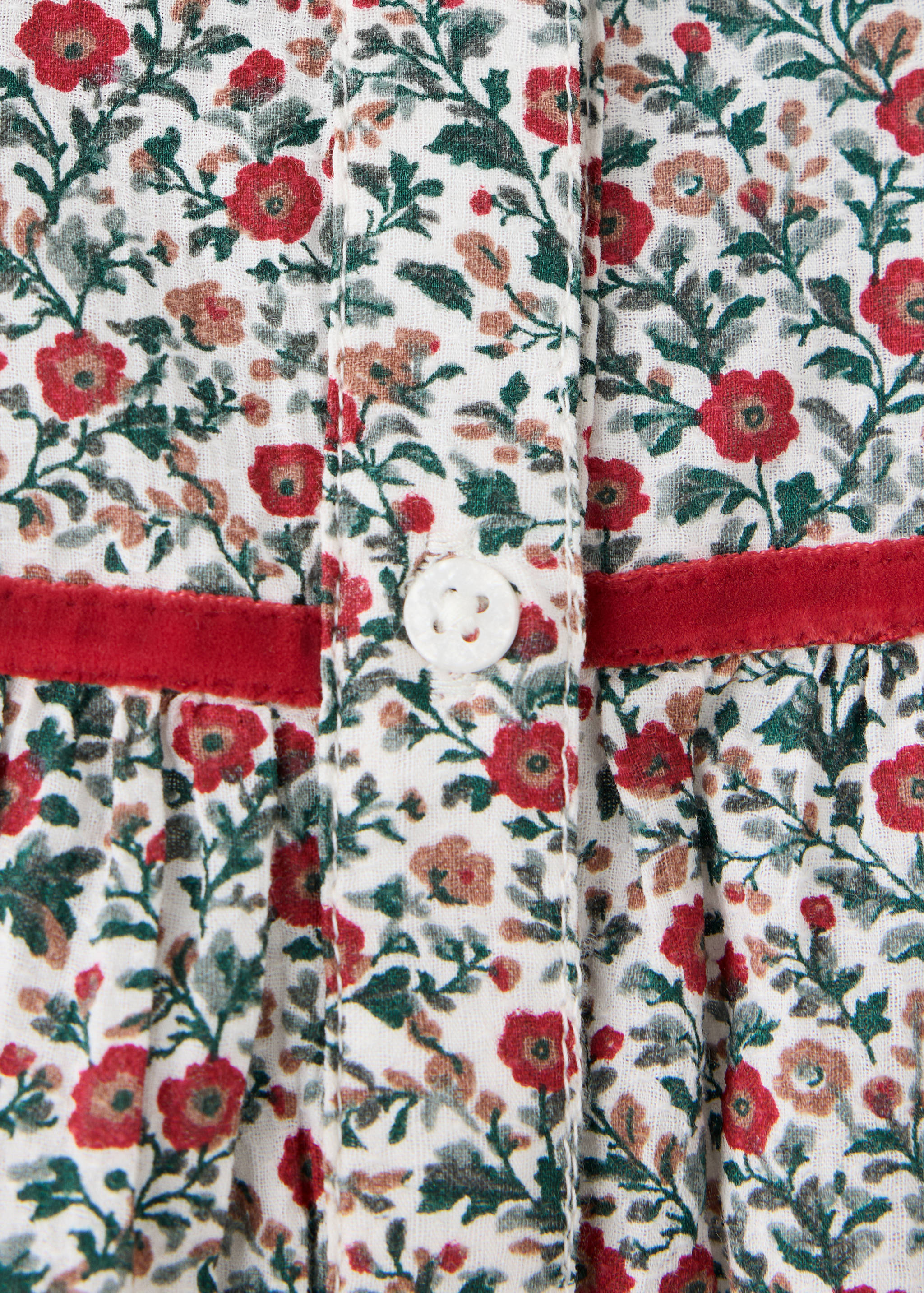 Close-up of a cream chunky knit dress with button details.