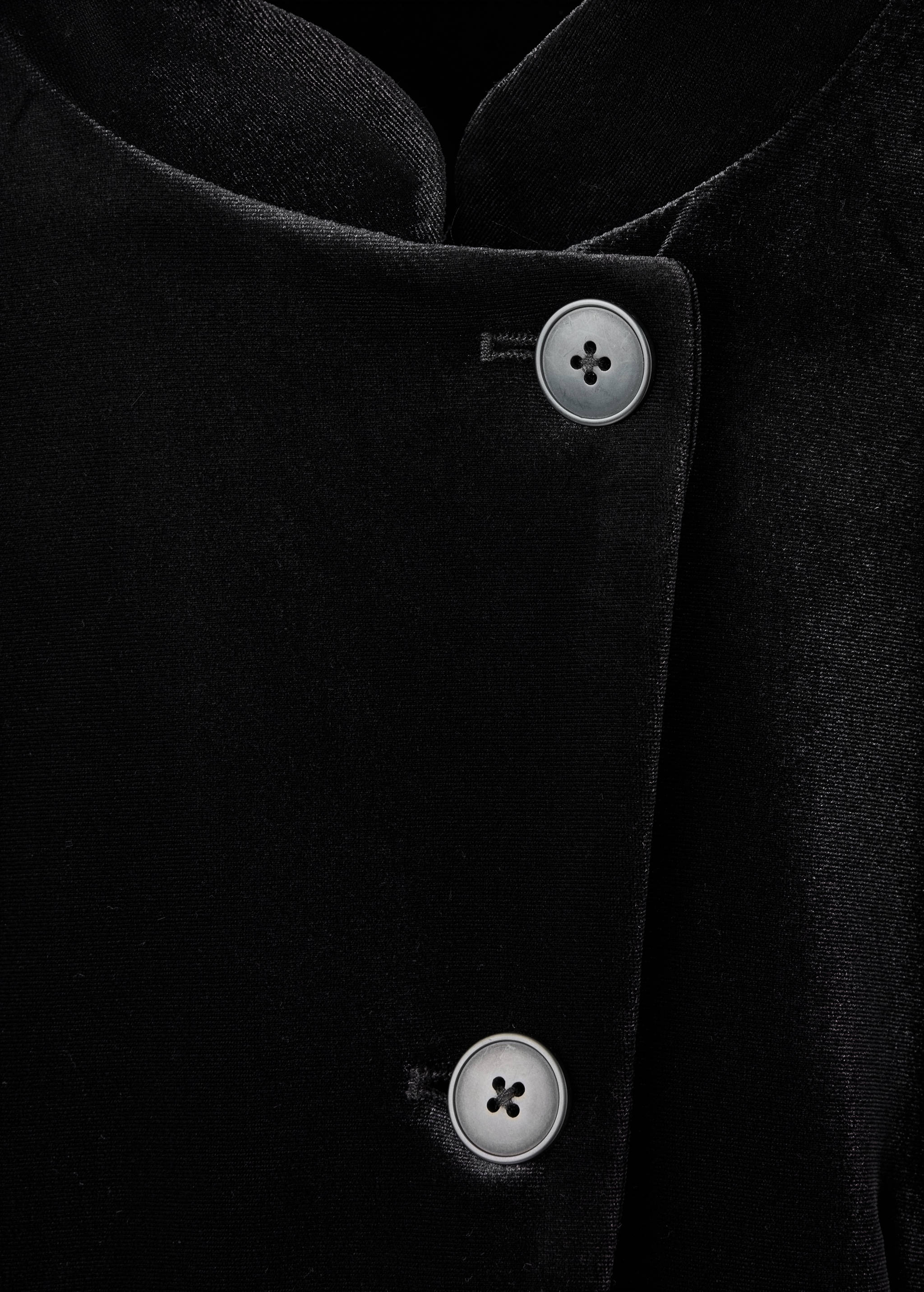 Black blazer detail showcasing light-grey front buttons.