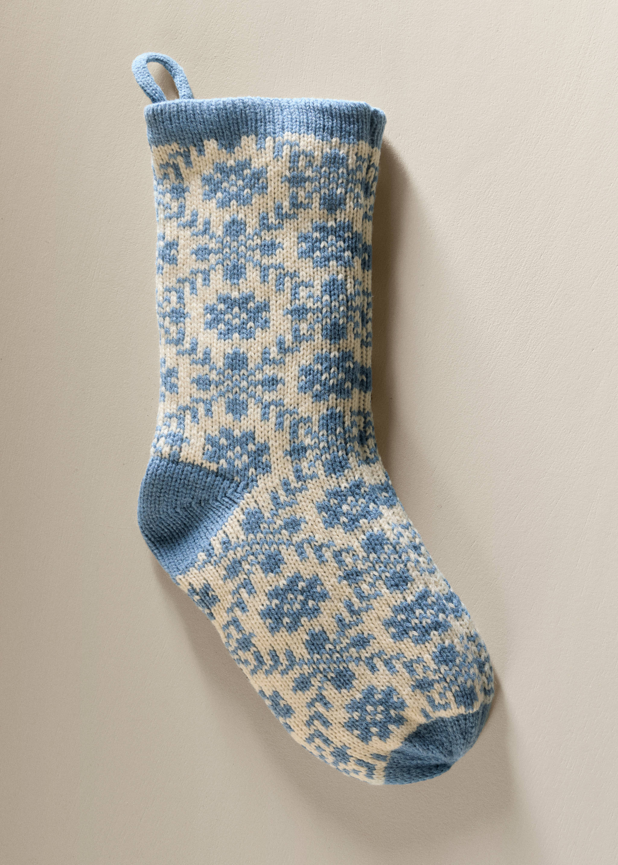 Blue and cream knitted Christmas stocking with a Nordic fair isle pattern.