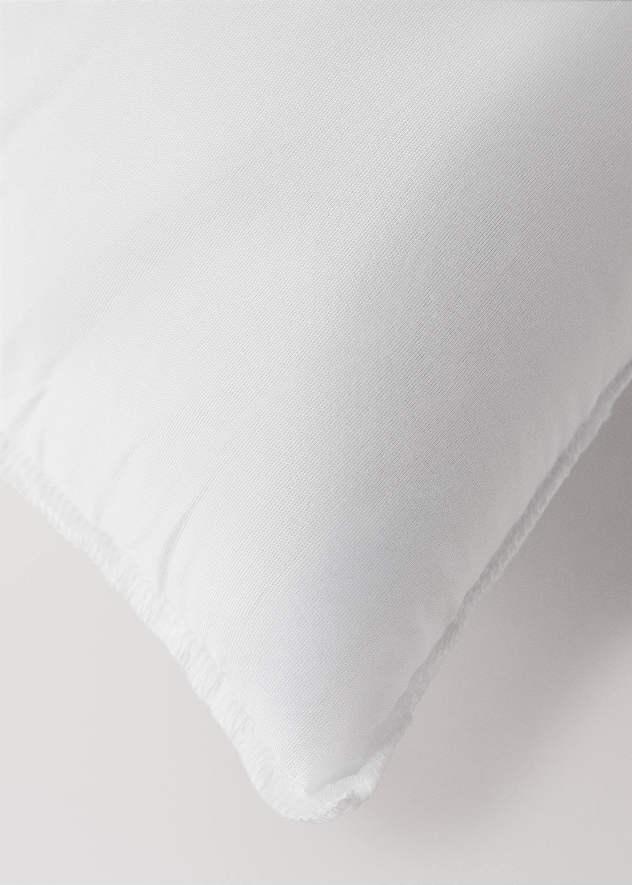 Close-up of a white pillow inner showing the fabric texture and corner seam., White. Ref: 37052563-00.