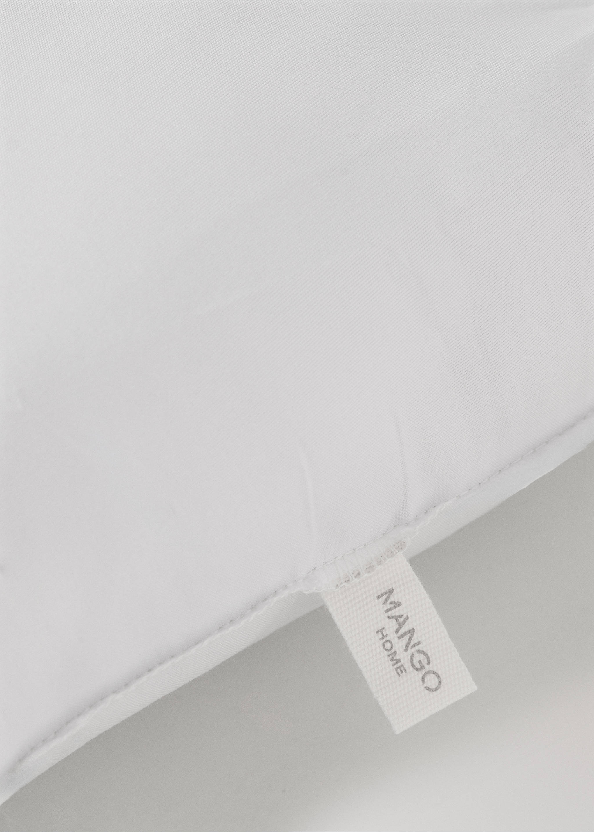 Close-up of a white pillow filler with a Mango Home label., White. Ref: 37052563-00.