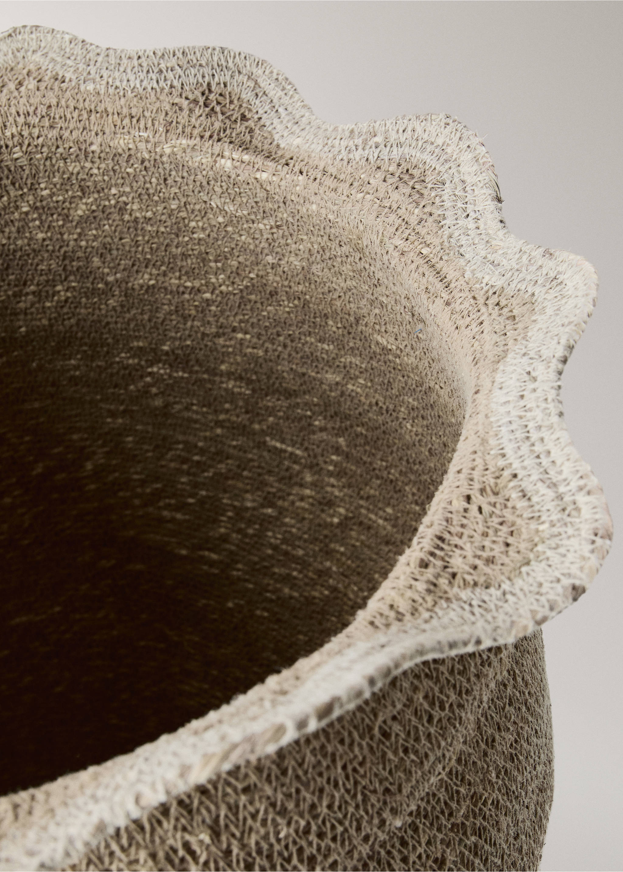 Close-up of a woven basket featuring a scalloped rim and textured beige fibrous material., Brown. Ref: 37053279-00.