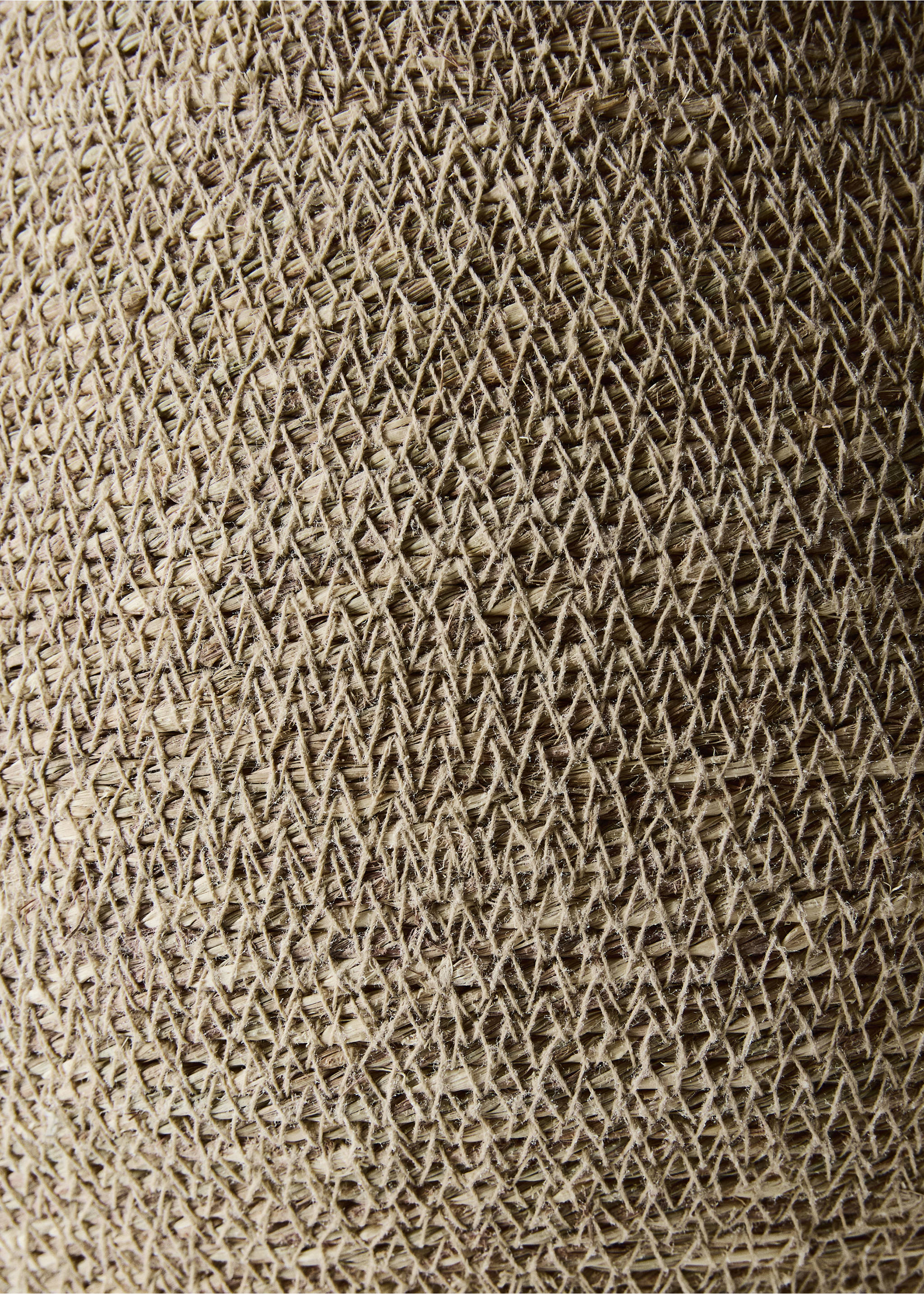 Close-up of a woven natural fiber basket showing the textured lattice pattern., Brown. Ref: 37053279-00.