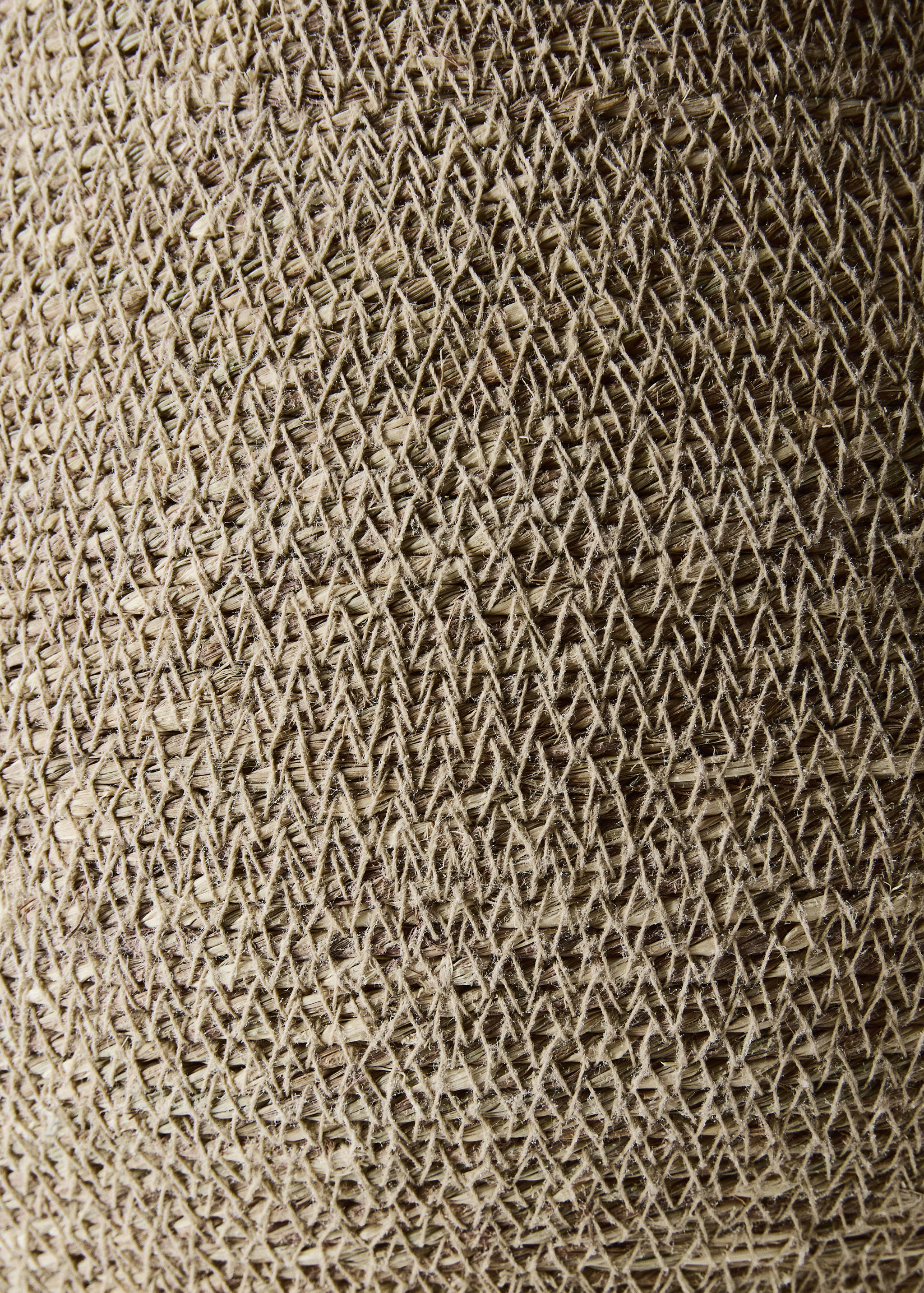 Close-up of a woven natural fiber basket showing the textured lattice pattern.